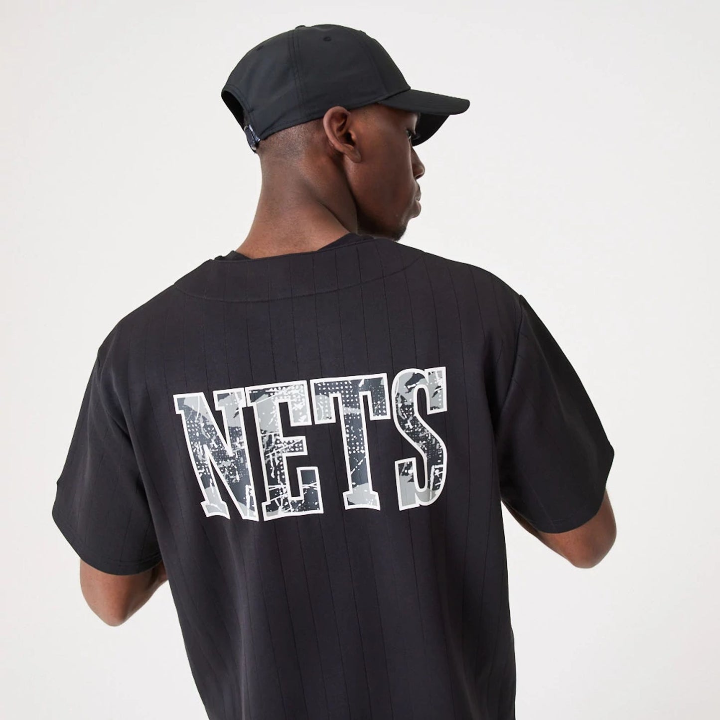 The Male model is wearing Brooklyn Nets NBA Infill Team Logo Black Jersey 3