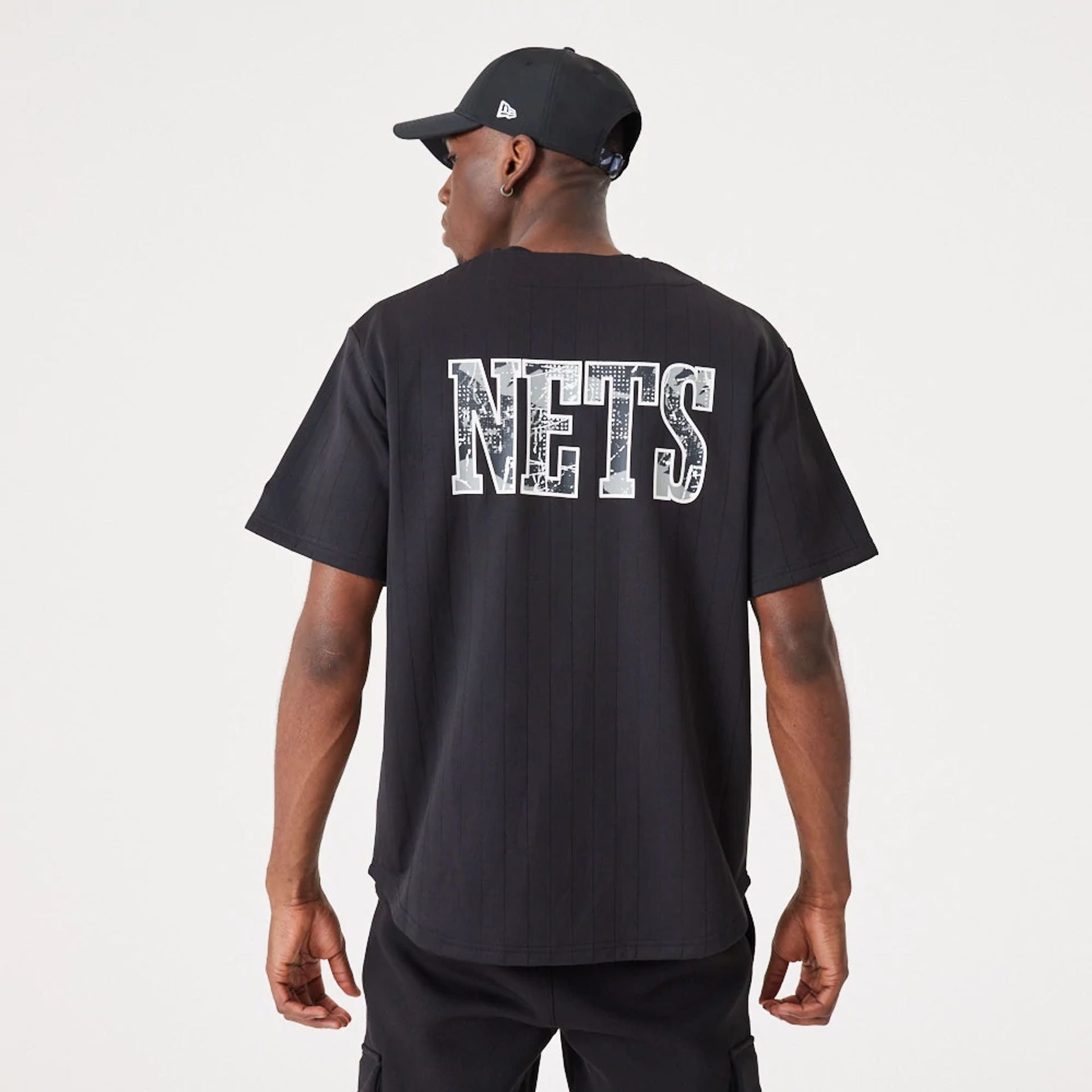 The Male model is wearing Brooklyn Nets NBA Infill Team Logo Black Jersey 1