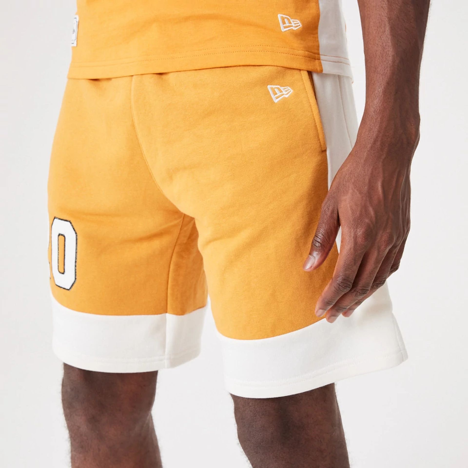 The Male model is wearing New Era Contemporary Medium Orange Oversized Shorts 4