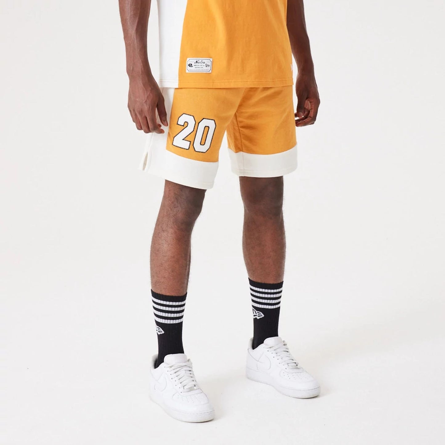 The Male model is wearing New Era Contemporary Medium Orange Oversized Shorts 1