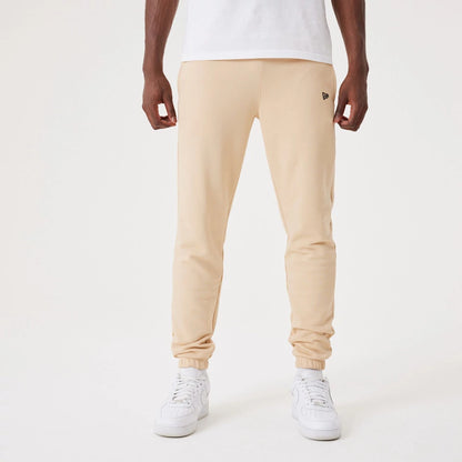 The Male model is wearing New Era Essential Light Beige Joggers 1