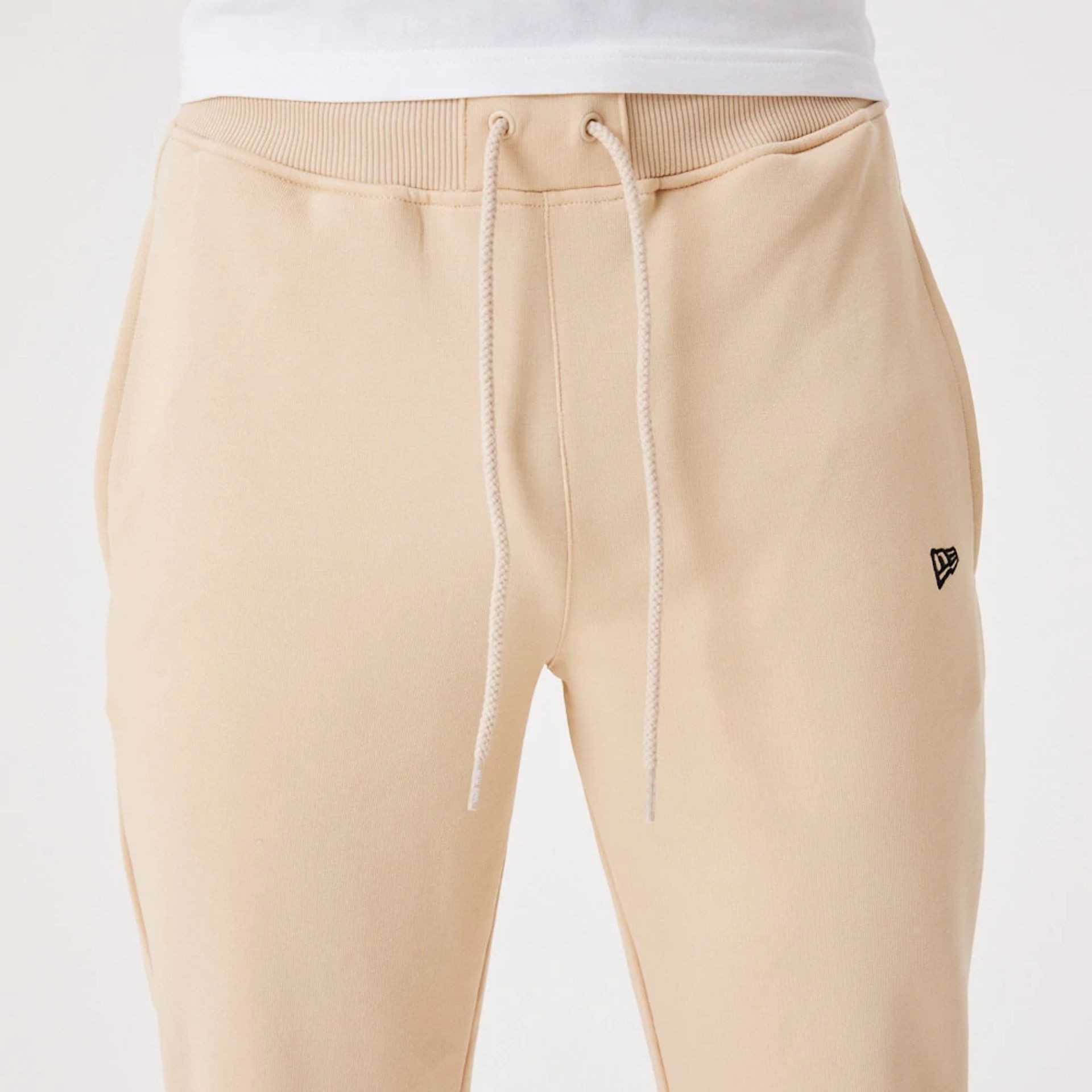 The Male model is wearing New Era Essential Light Beige Joggers 6