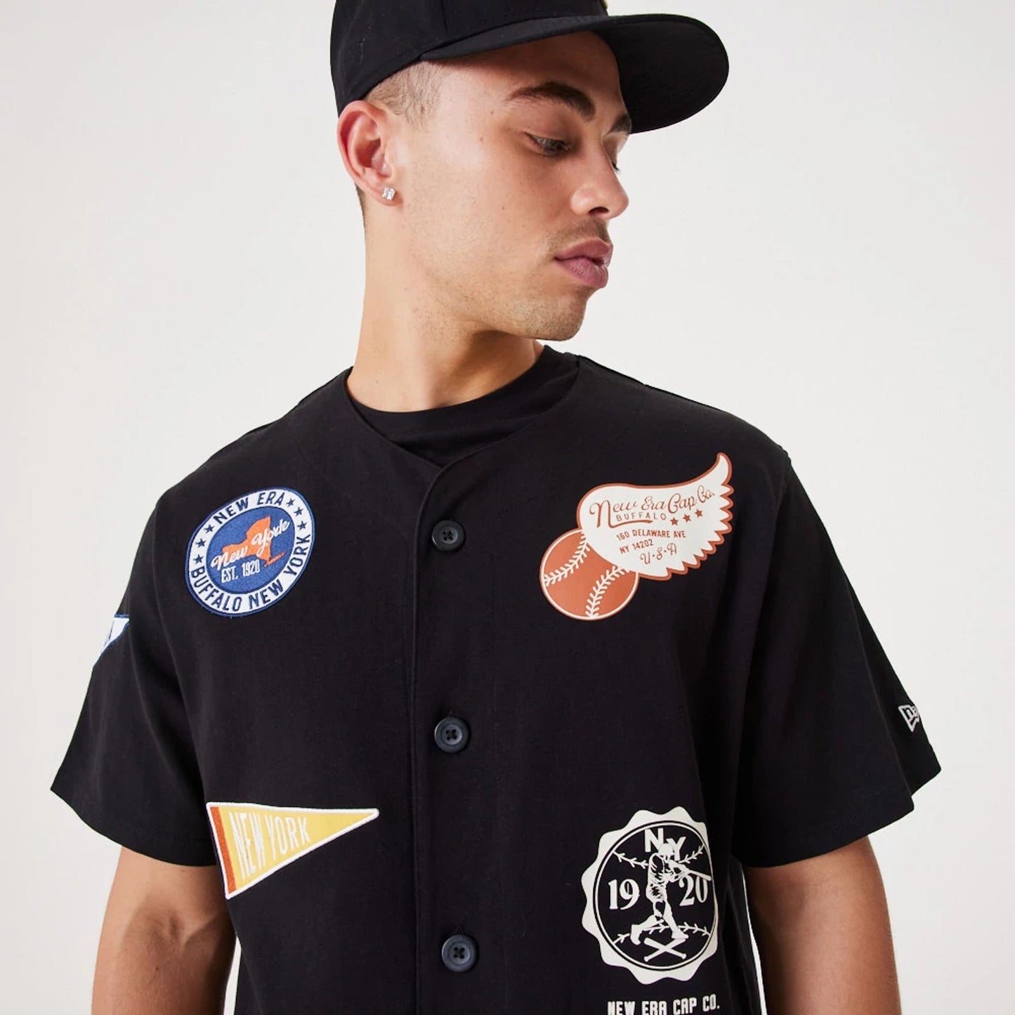 The Male model is wearing New Era Heritage Badge Black Jersey 8