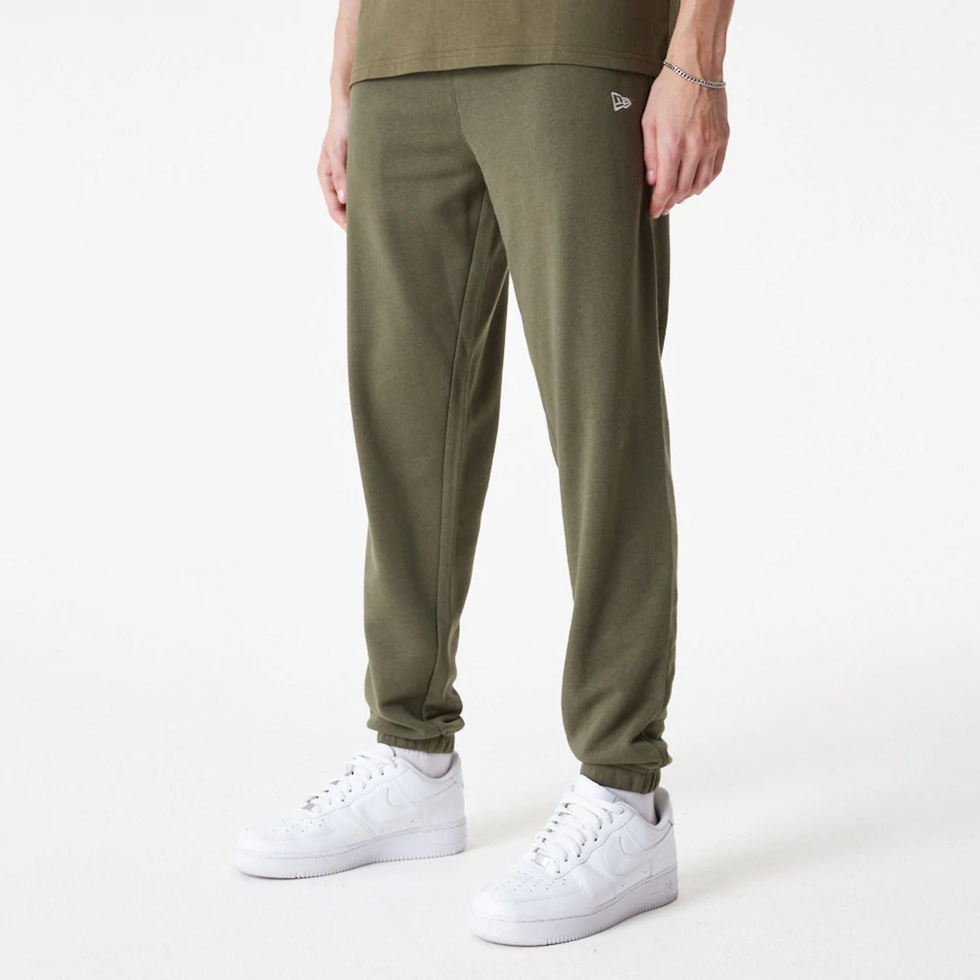 The Male model is wearing New Era Essential Green Joggers 1