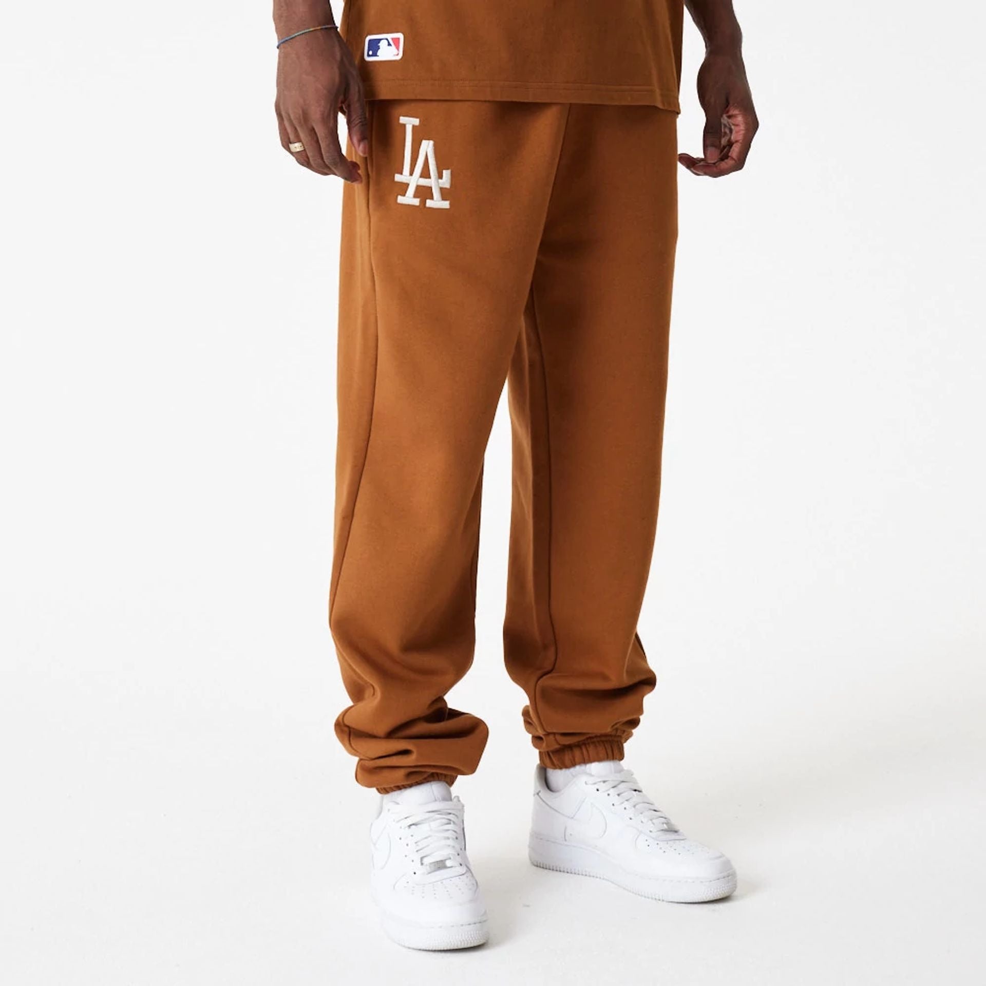 The Male model is wearing LA Dodgers League Essential Brown Joggers 1