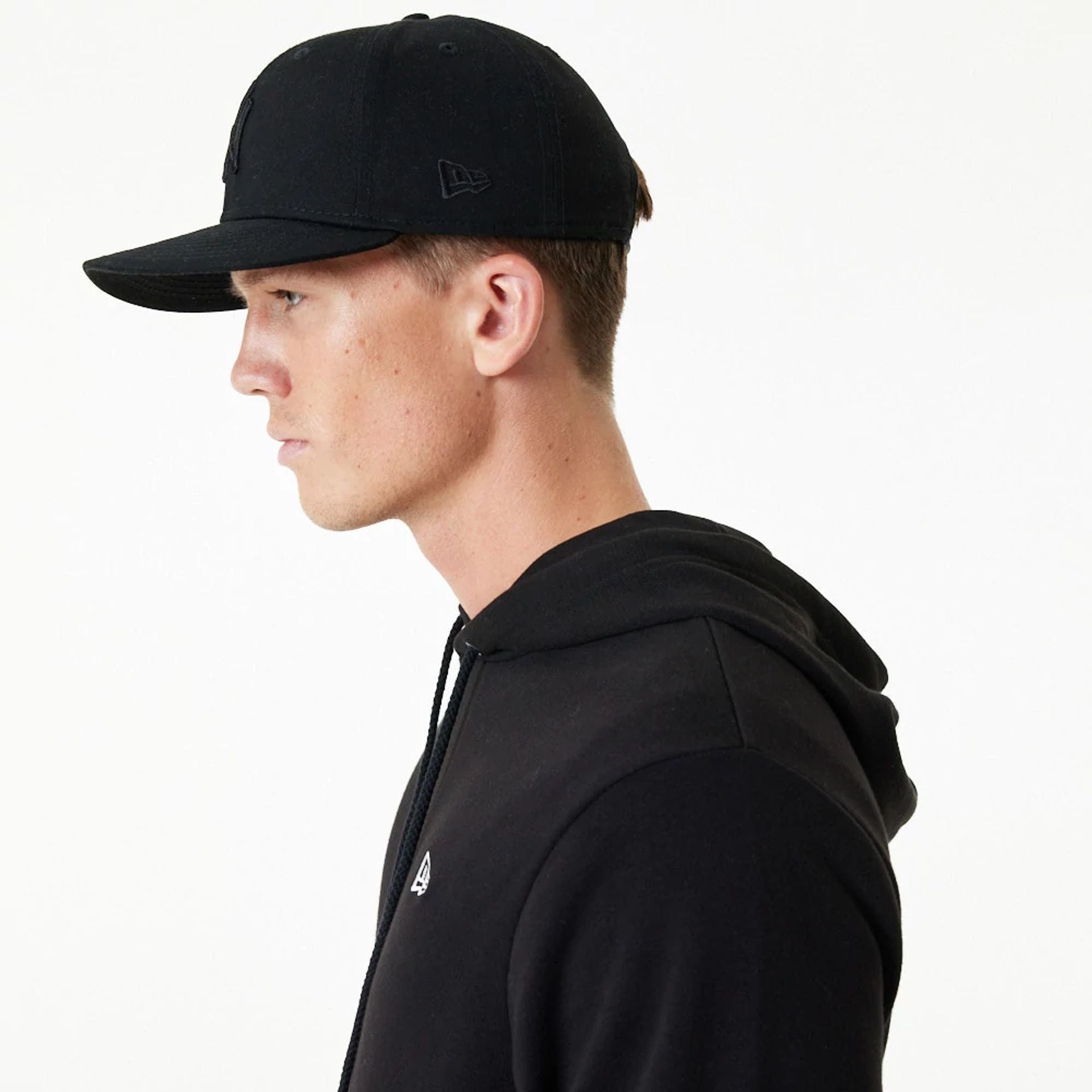 The Male model is wearing New Era Essential Black Pullover Hoodie 3