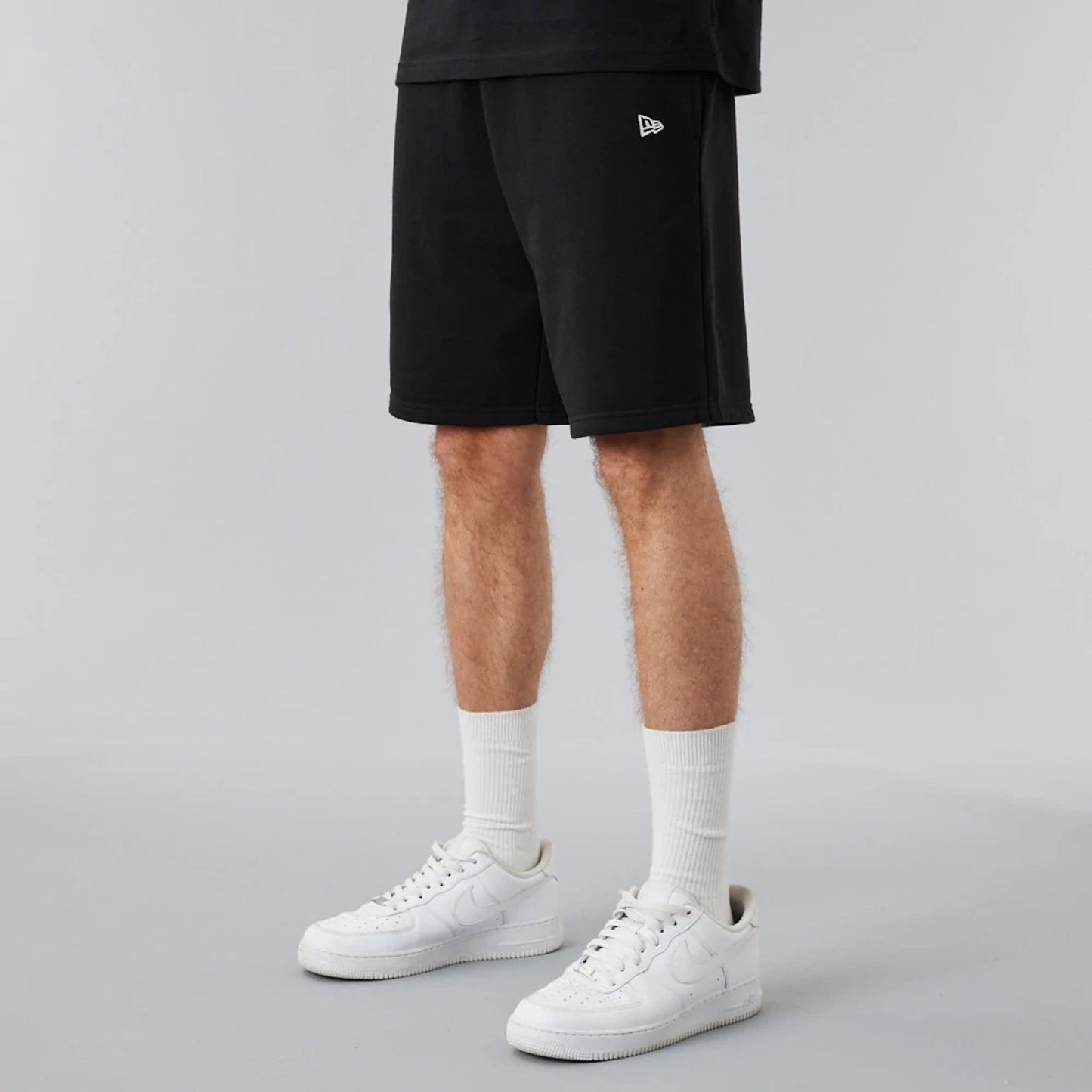 The Male model is wearing New Era Essential Black Shorts 2