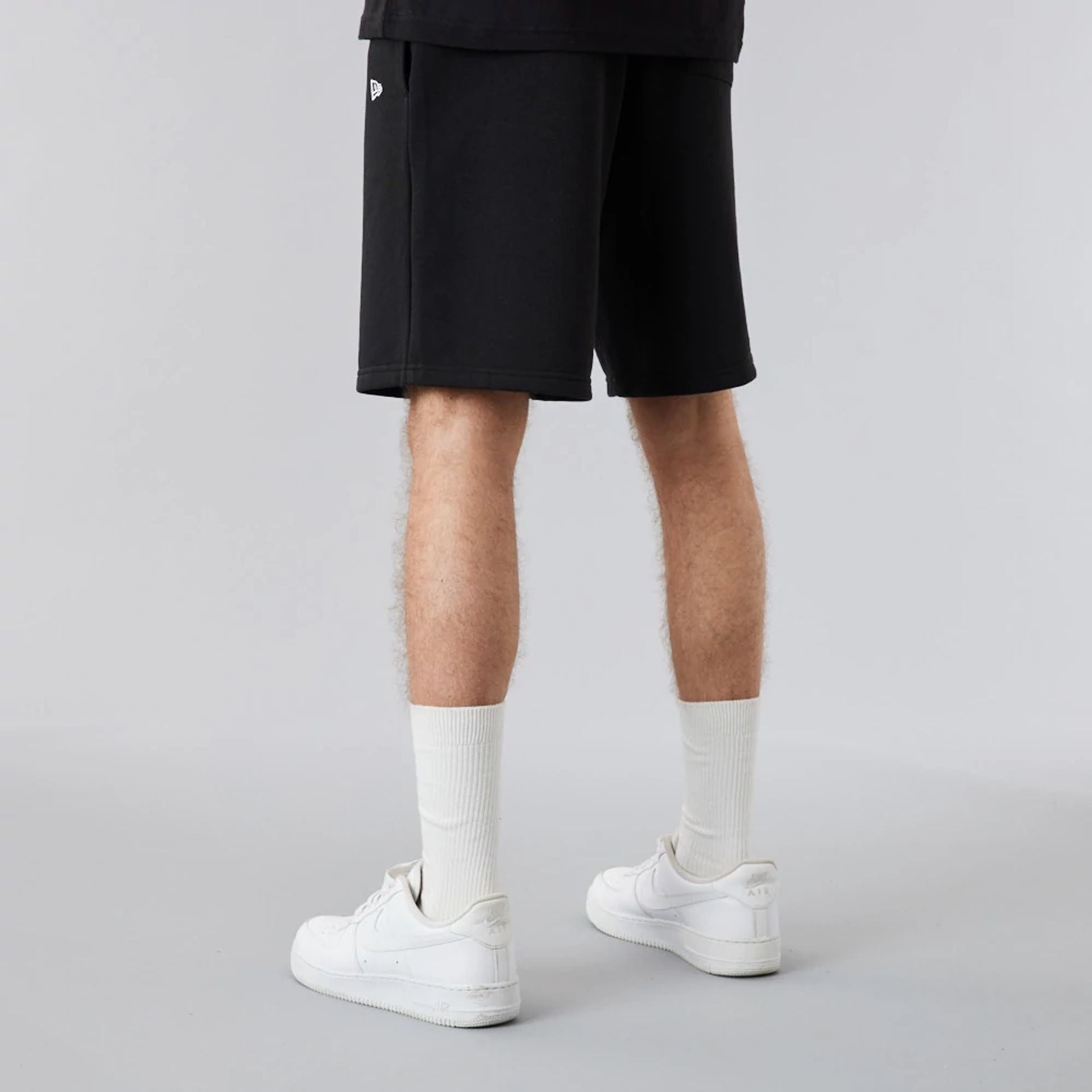 The Male model is wearing New Era Essential Black Shorts 3