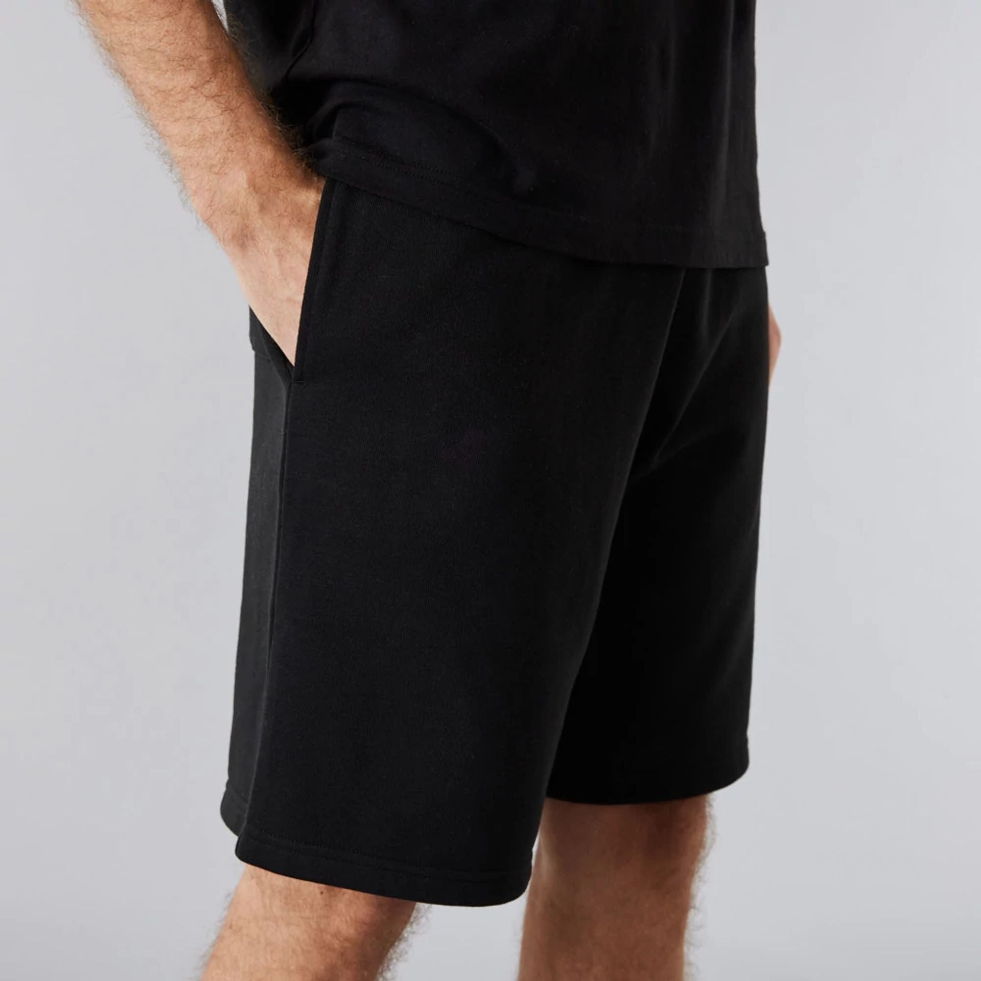 The Male model is wearing New Era Essential Black Shorts 5