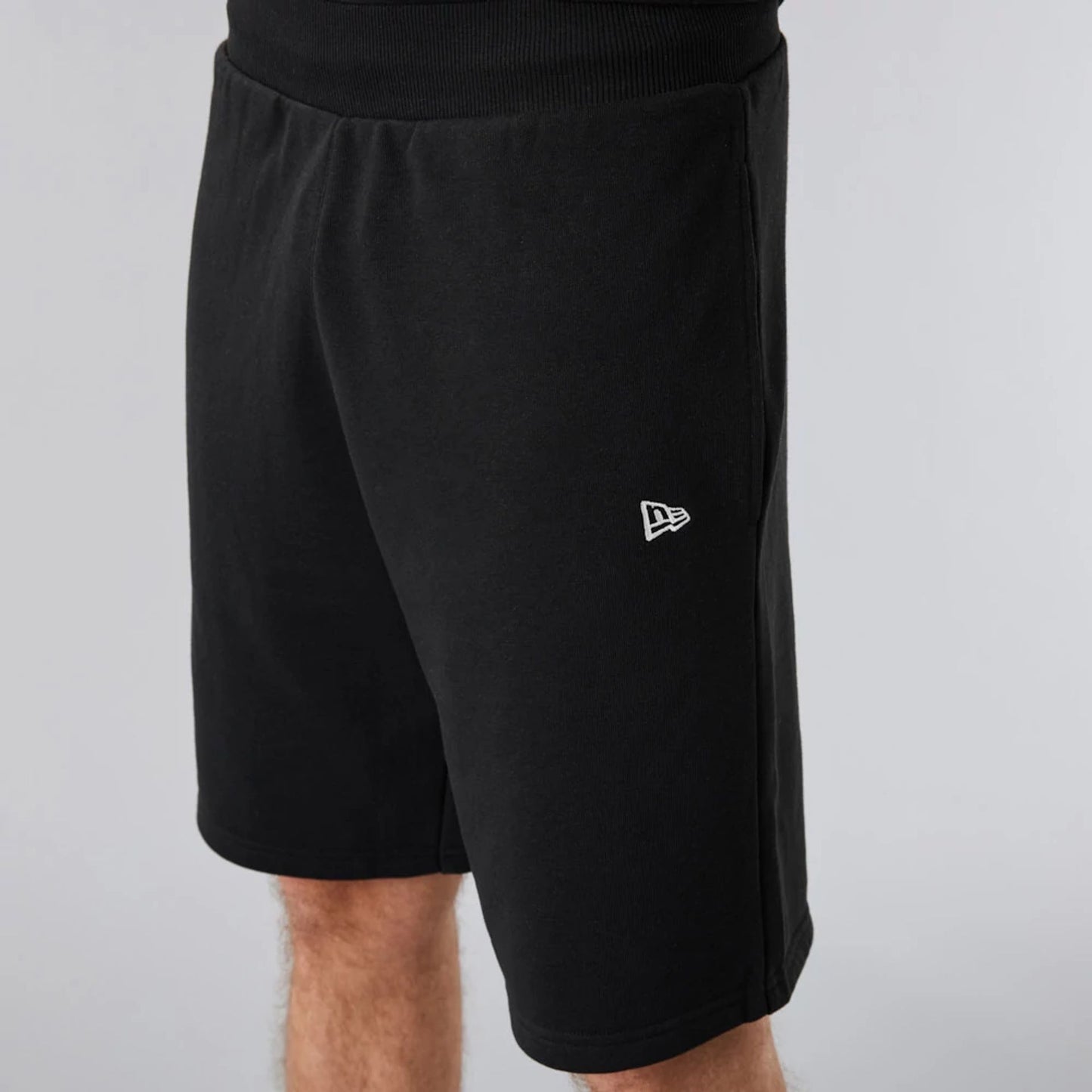 The Male model is wearing New Era Essential Black Shorts 6