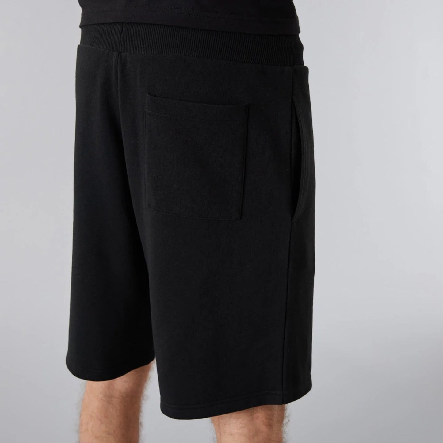 The Male model is wearing New Era Essential Black Shorts 7