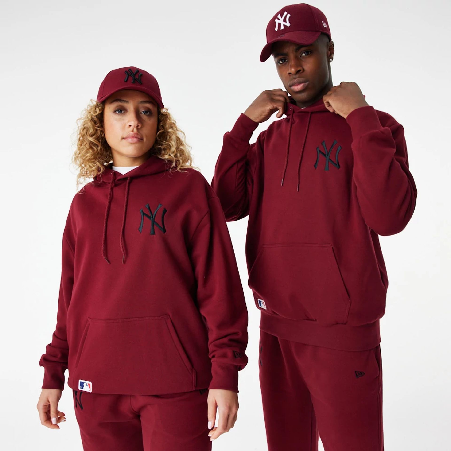 The Male model is wearing New York Yankees League Essential Red Oversized Hoodie 1