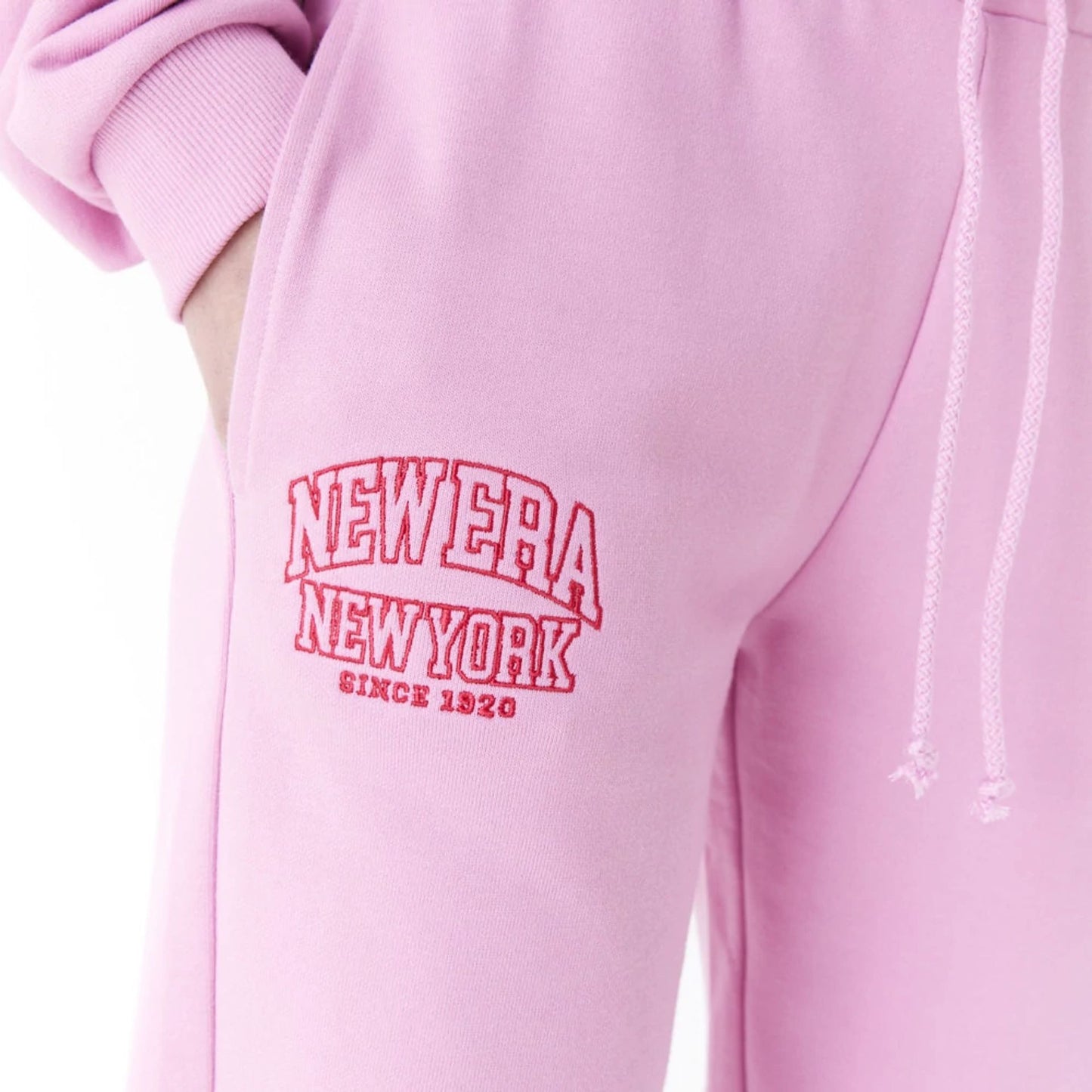 The Female model is wearing New Era Womens Arch Wordmark Pink Joggers 6