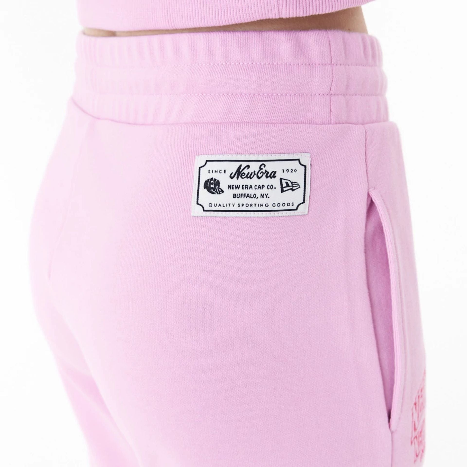 The Female model is wearing New Era Womens Arch Wordmark Pink Joggers 8