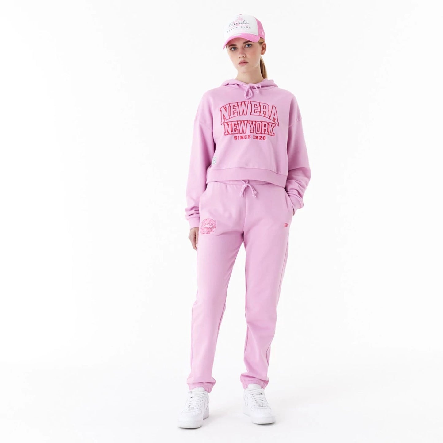 The Female model is wearing New Era Womens Arch Wordmark Pink Joggers 2