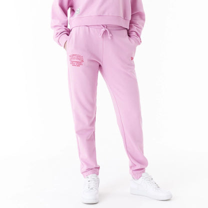 The Female model is wearing New Era Womens Arch Wordmark Pink Joggers 1