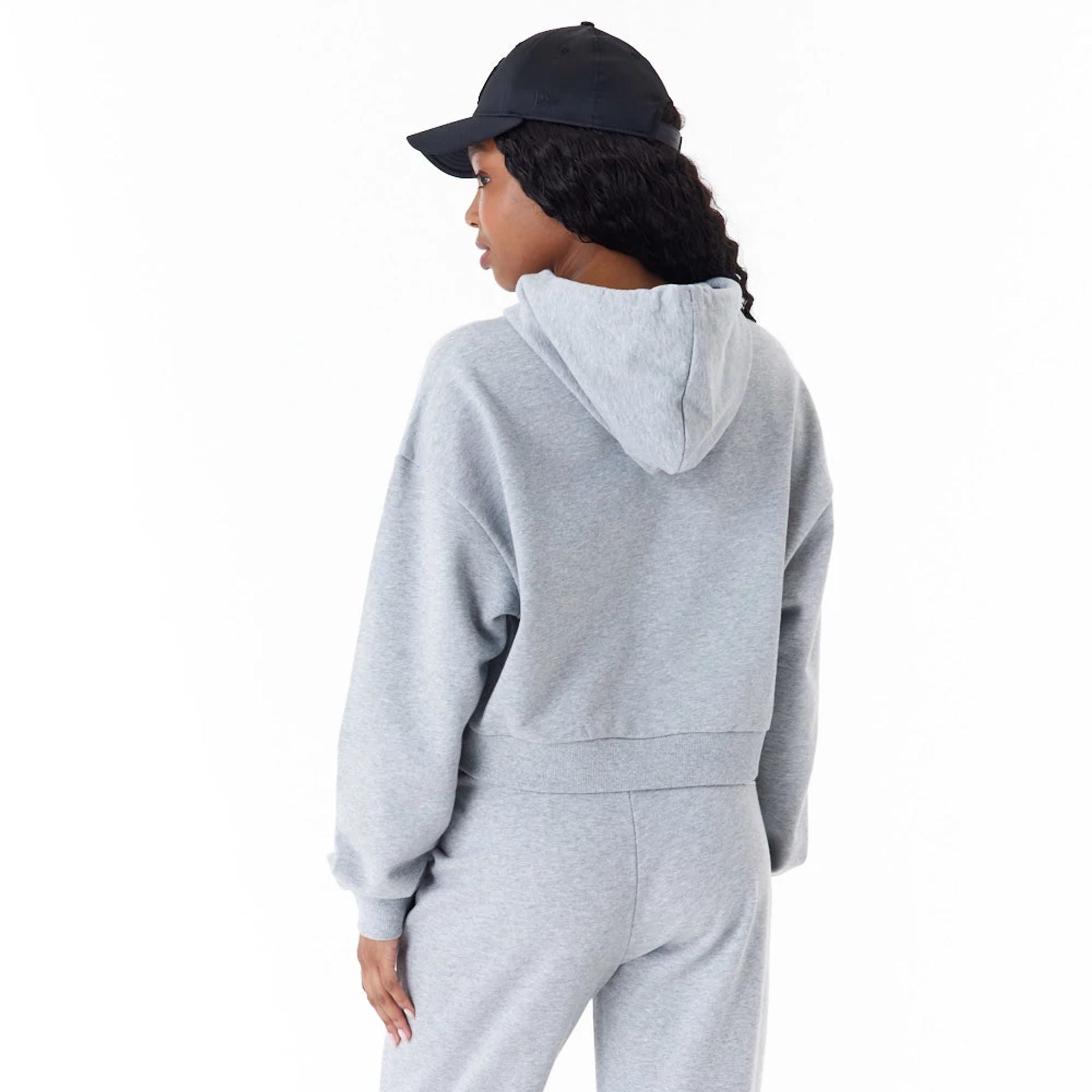 The Female model is wearing New Era Womens Arch Wordmark Grey Crop Pullover Hoodie 3