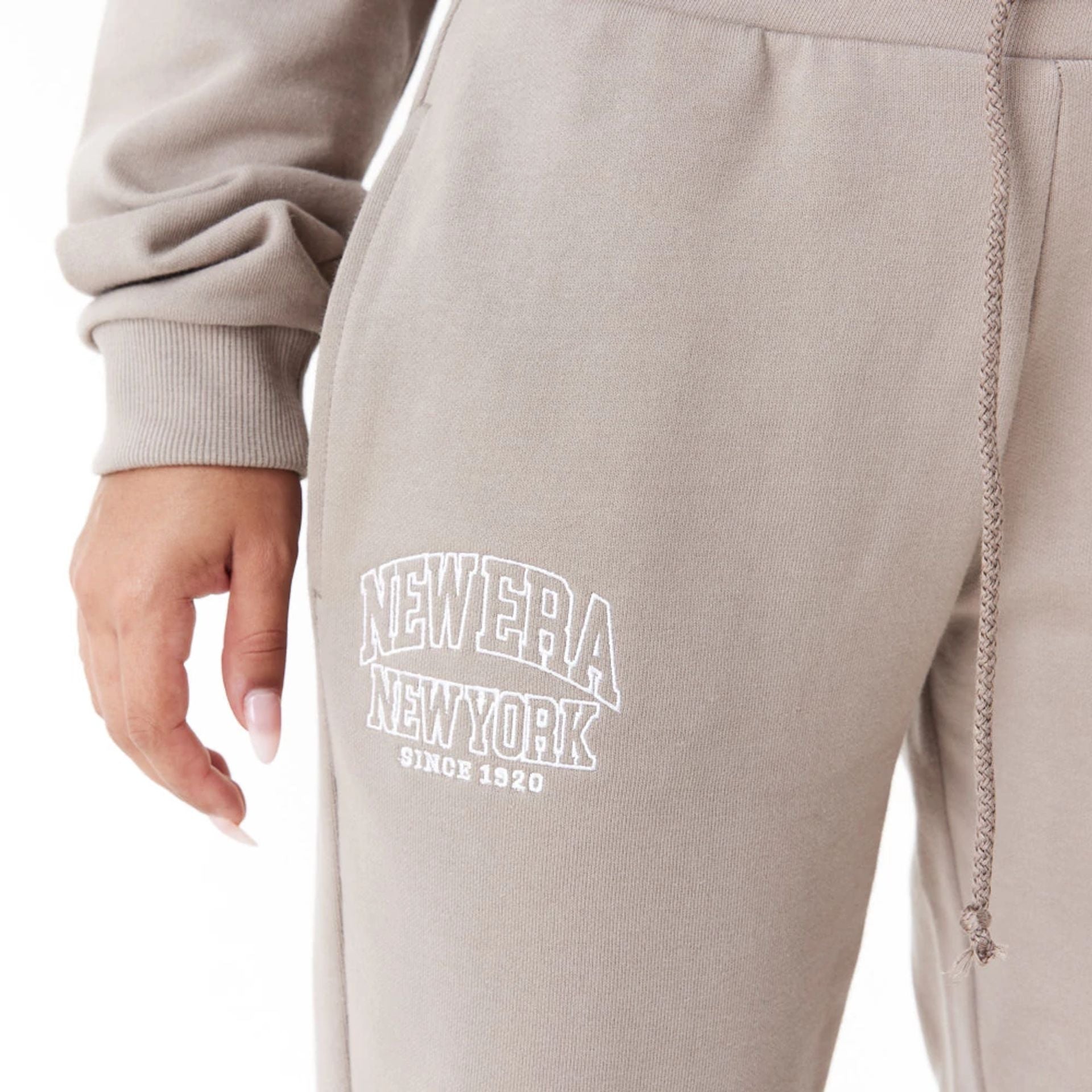 The Female model is wearing New Era Womens Arch Wordmark Brown Joggers 8