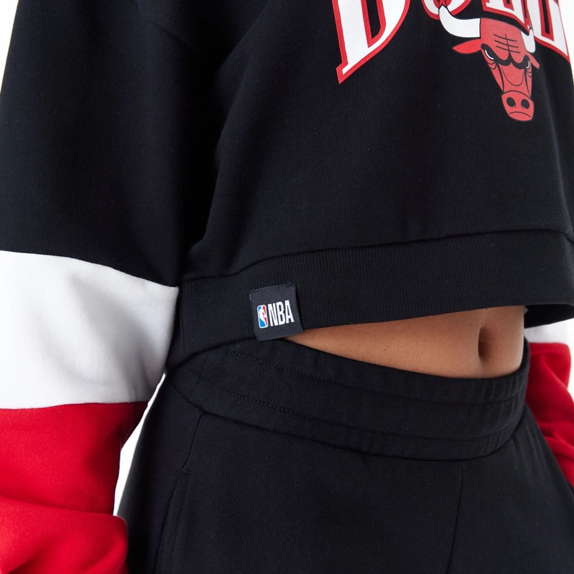 The Female model is wearing Chicago Bulls Womens NBA Colour Block Black Crop Crew Neck Sweatshirt 4