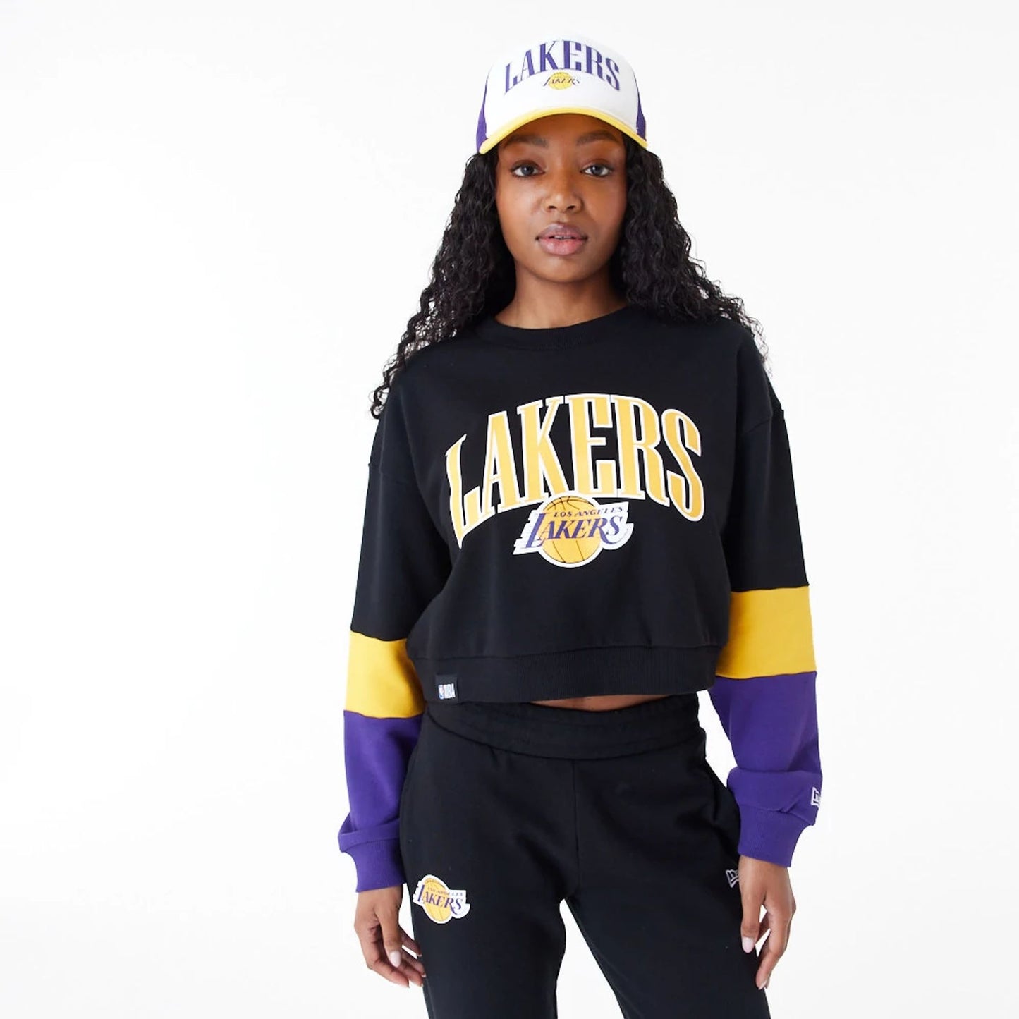 The Female model is wearing LA Lakers Womens NBA Colour Block Black Crop Crew Neck Sweatshirt 1