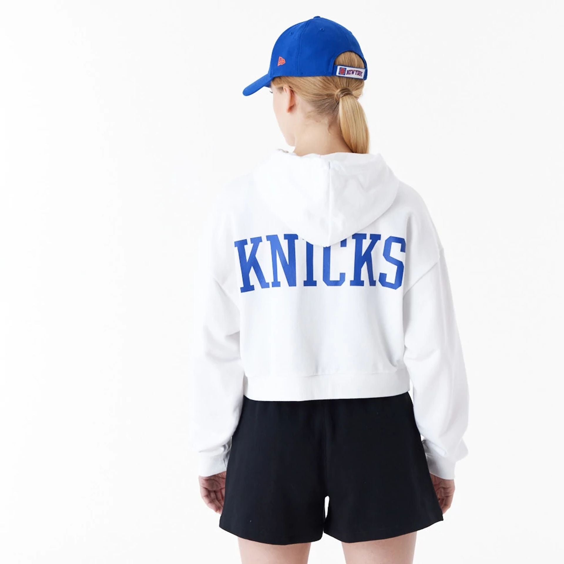 The Female model is wearing New York Knicks Womens NBA Team Logo White Crop Pullover Hoodie 2