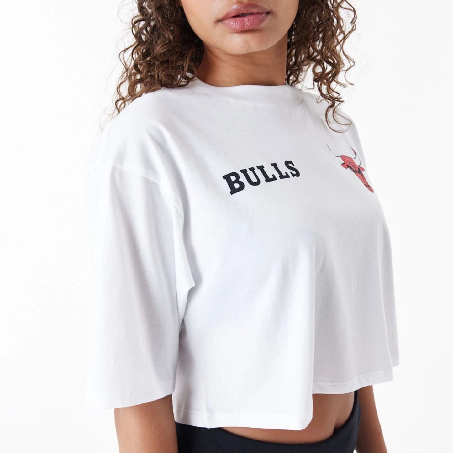 The Female model is wearing Chicago Bulls Womens NBA Team Logo White Crop T-Shirt 7