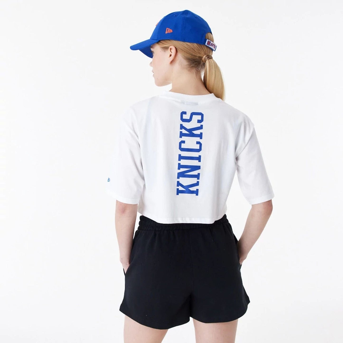 The Female model is wearing New York Knicks Womens NBA Team Logo White Crop T-Shirt 7