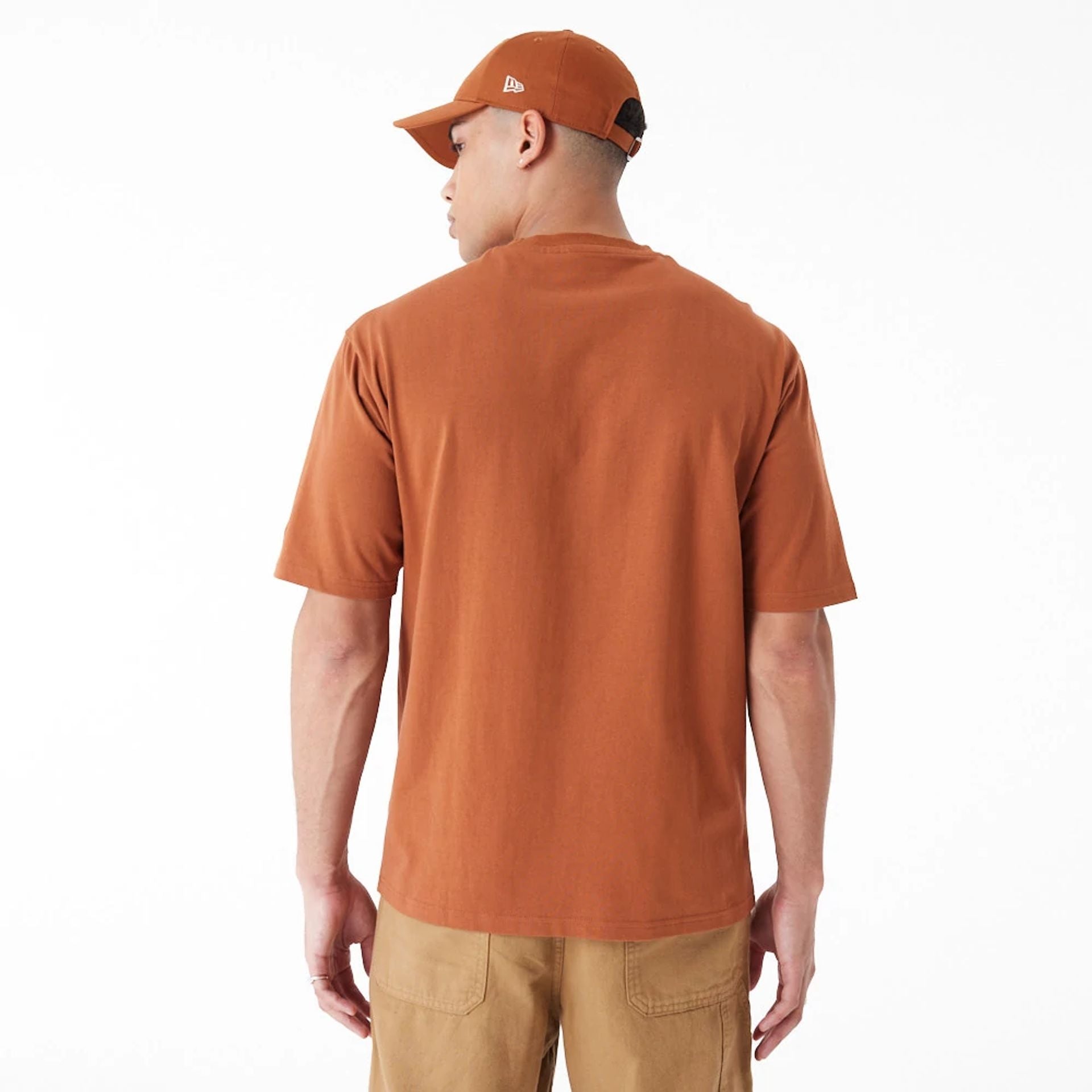 The Male model is wearing New Era Heritage Patch Brown Oversized T-Shirt 2