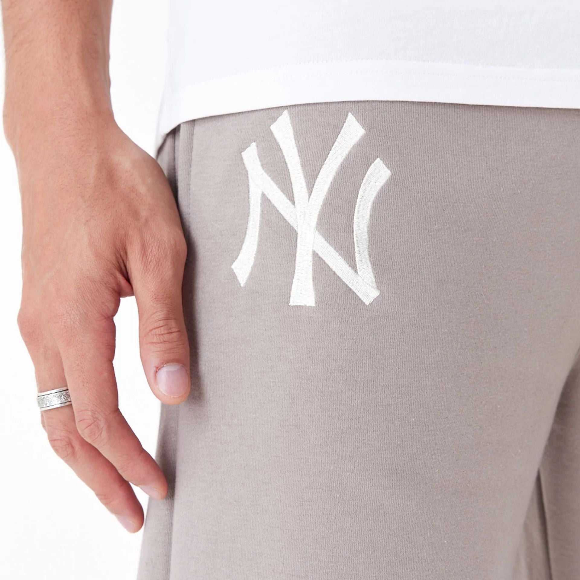 The Male model is wearing New York Yankees League Essential Beige Joggers 4