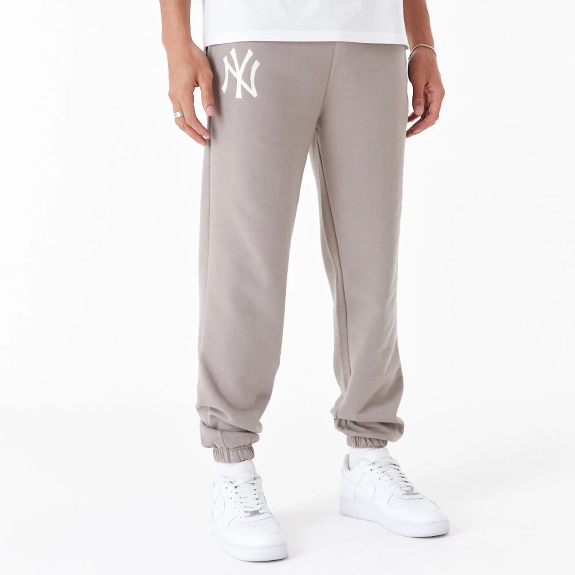 The Male model is wearing New York Yankees League Essential Beige Joggers 1