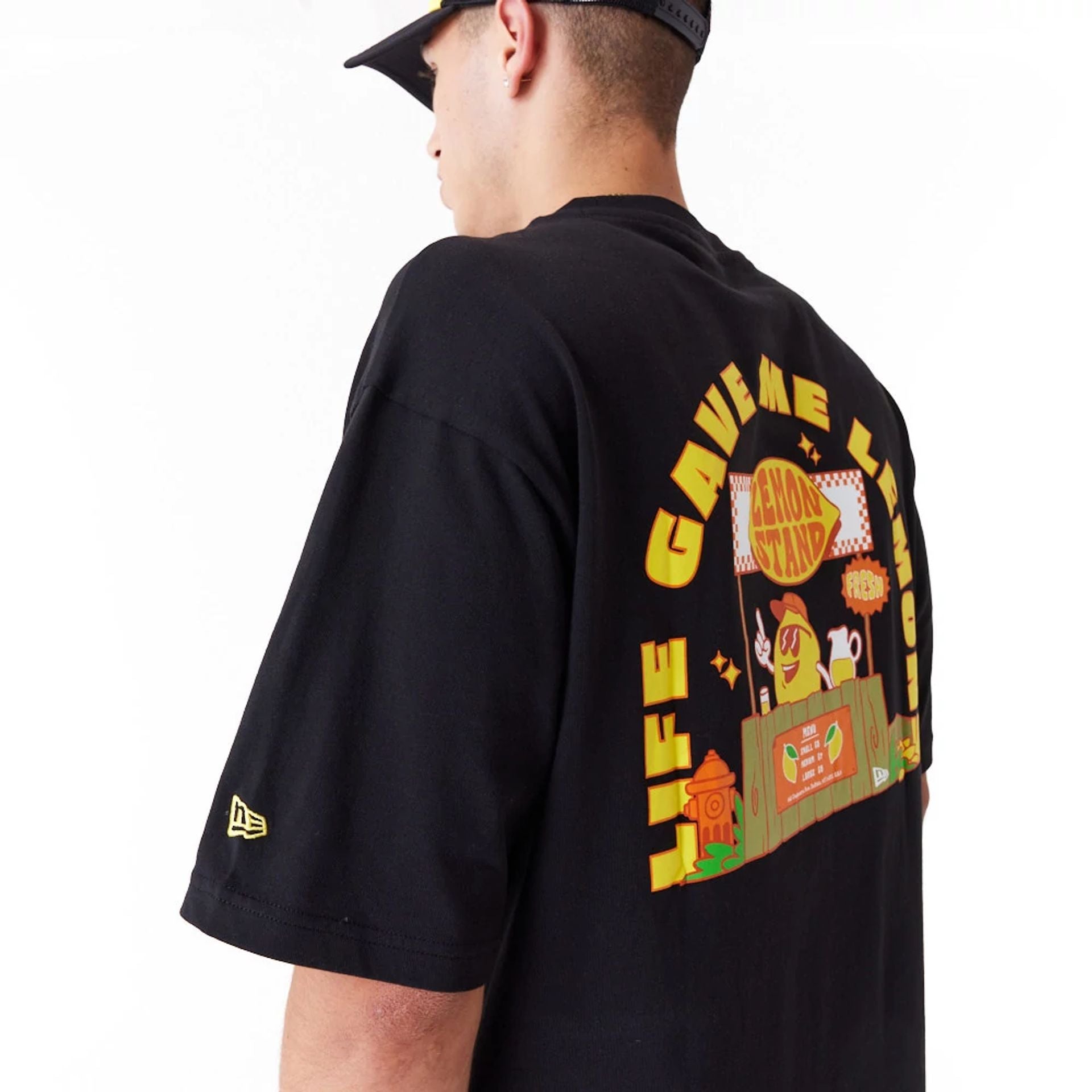 The Male model is wearing New Era Lemon Stand Fruit Graphic Black Oversized T-Shirt 2