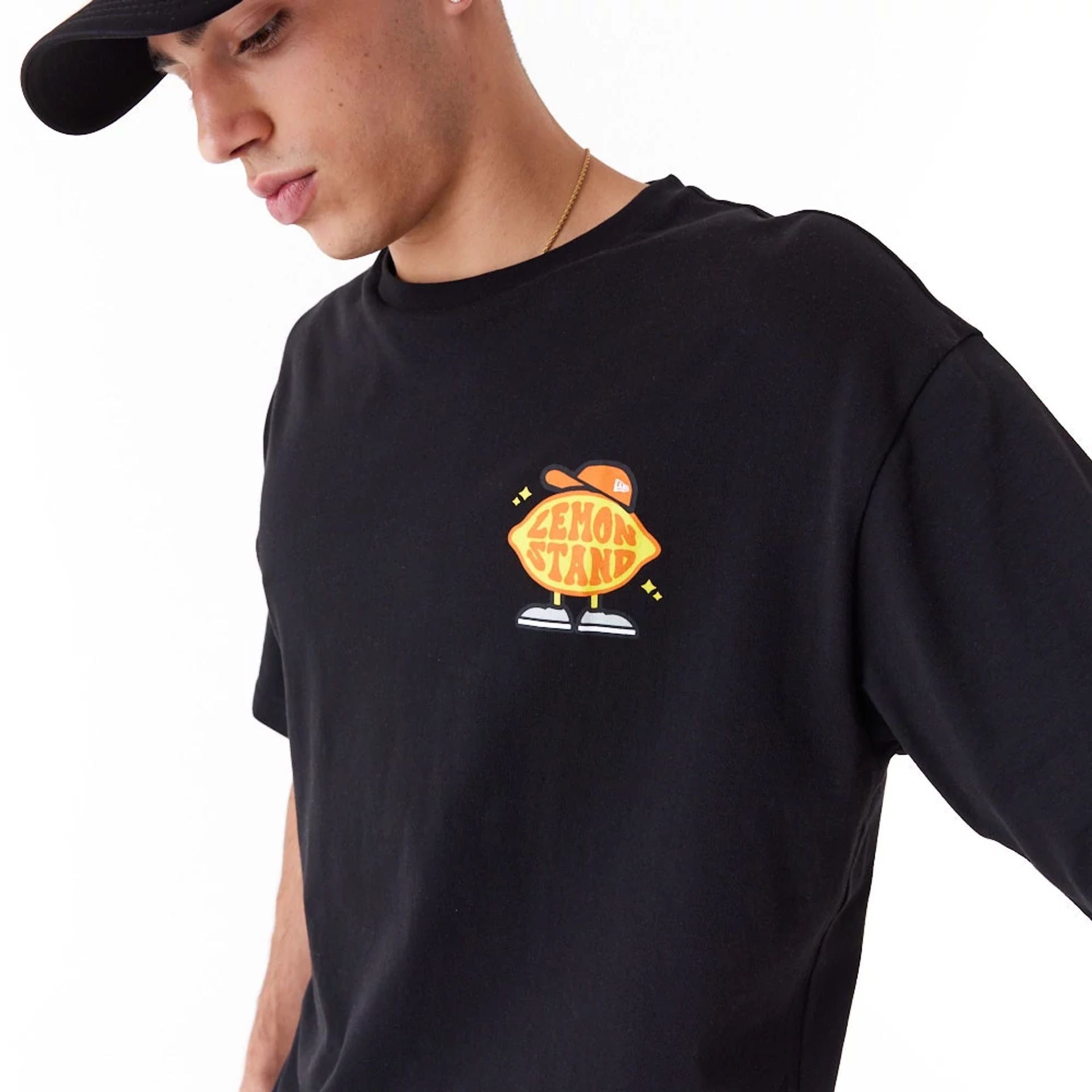 The Male model is wearing New Era Lemon Stand Fruit Graphic Black Oversized T-Shirt 3