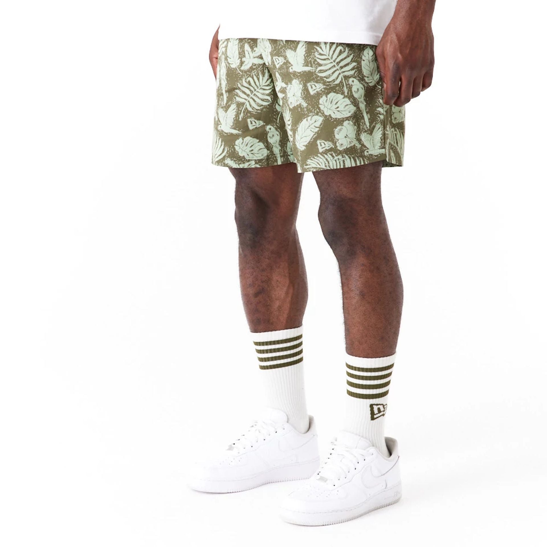 The Male model is wearing New Era All Over Print Green Woven Shorts 2