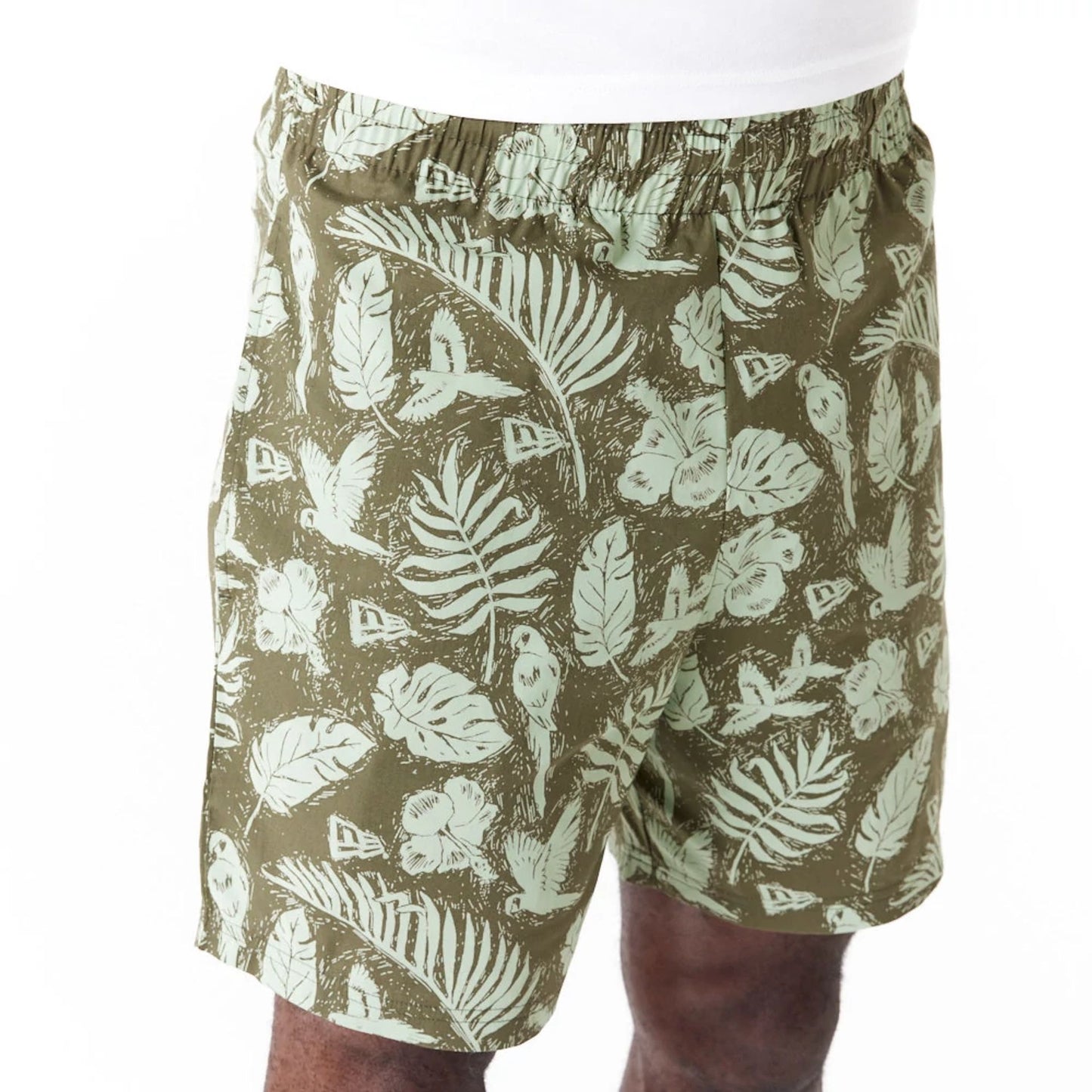 The Male model is wearing New Era All Over Print Green Woven Shorts 5