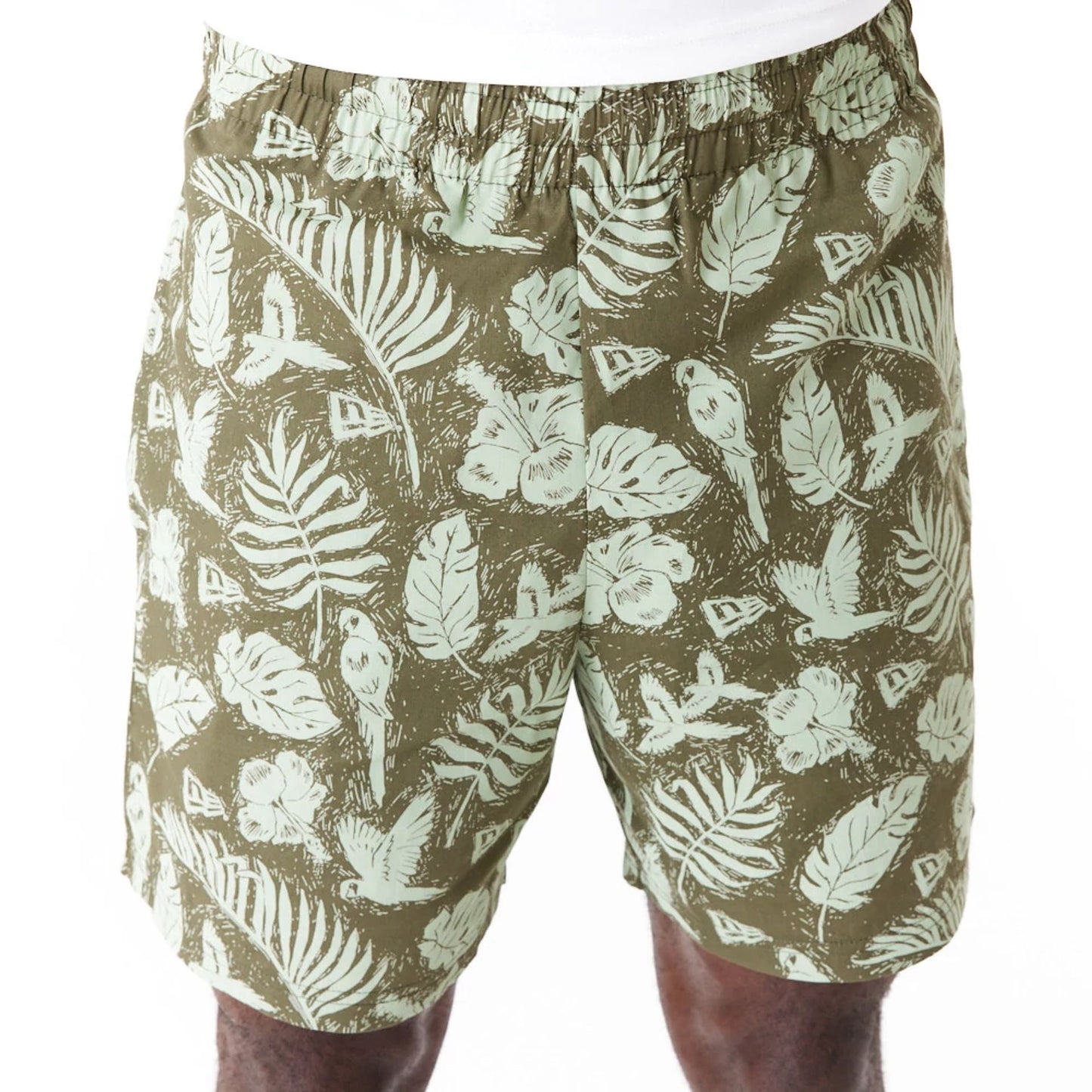 The Male model is wearing New Era All Over Print Green Woven Shorts 6