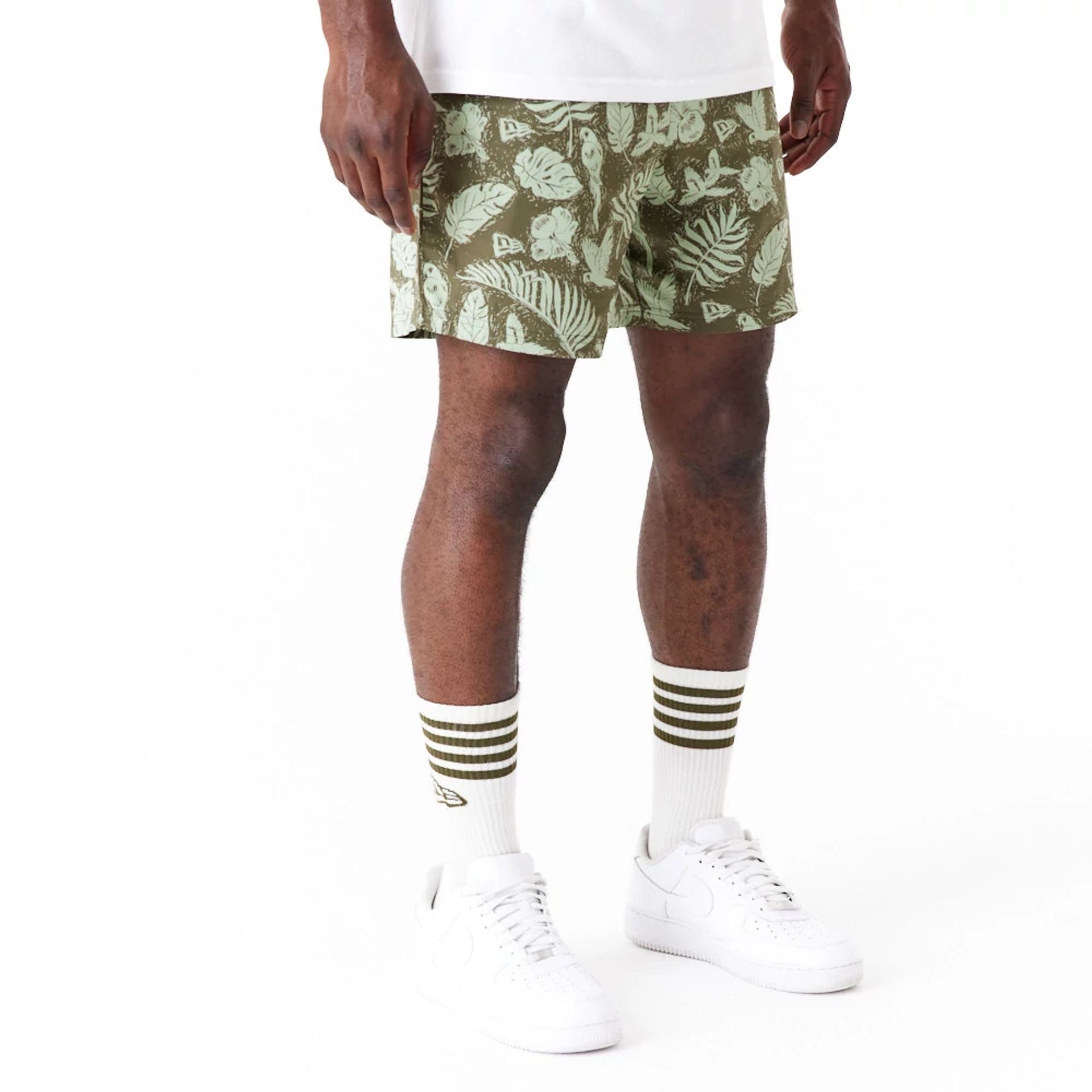 The Male model is wearing New Era All Over Print Green Woven Shorts 7