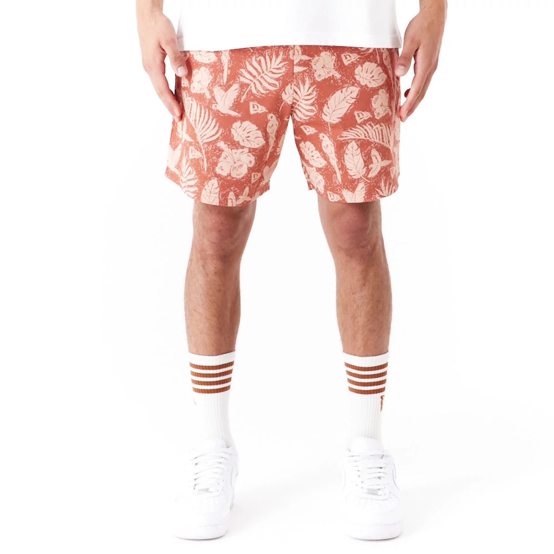 The Male model is wearing New Era All Over Print Brown Woven Shorts 1