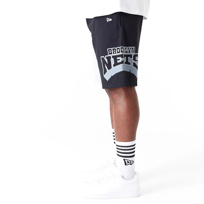 The Male model is wearing Brooklyn Nets NBA Graphic Grey Shorts 4