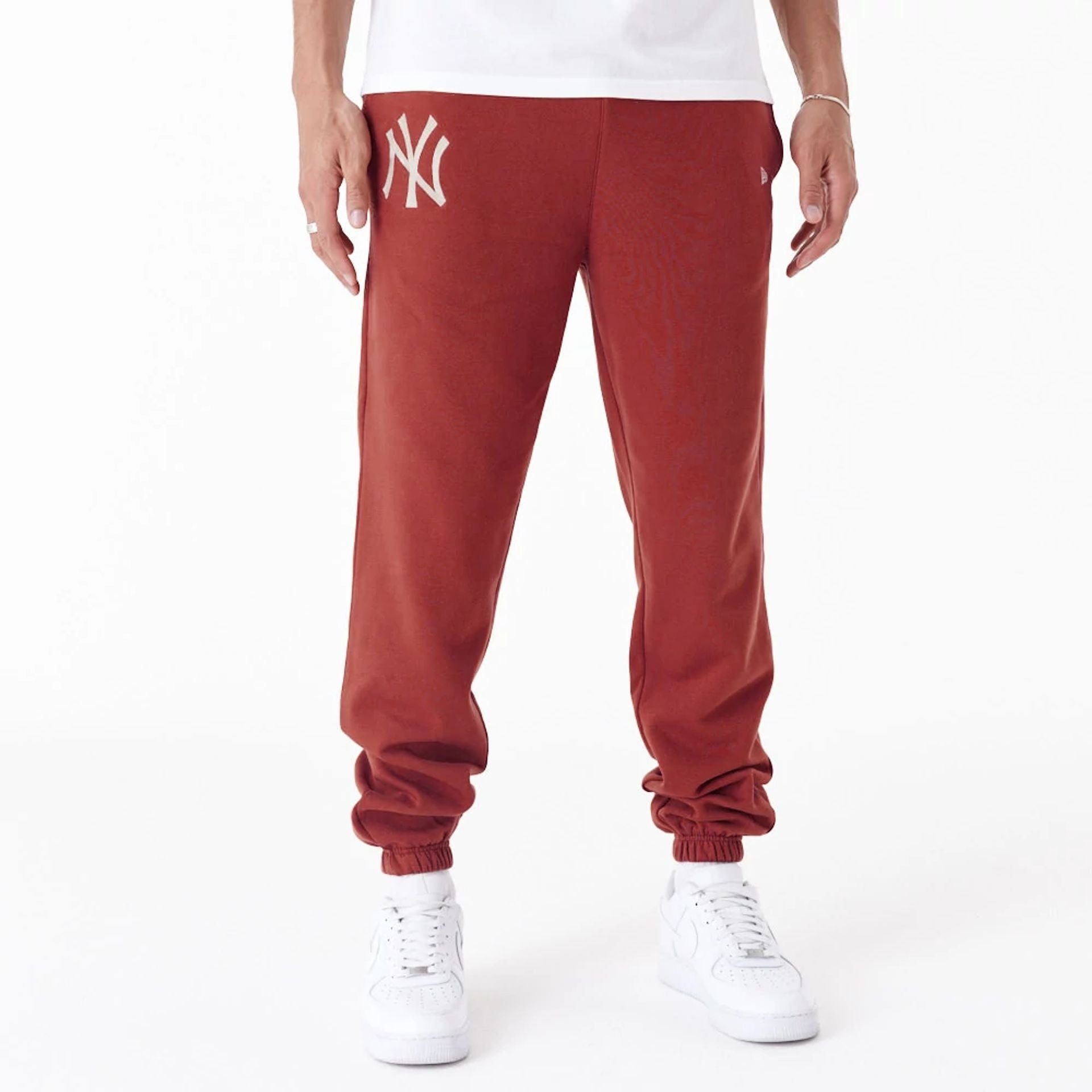 The Male model is wearing New York Yankees League Essential Copper Fleece Joggers 1