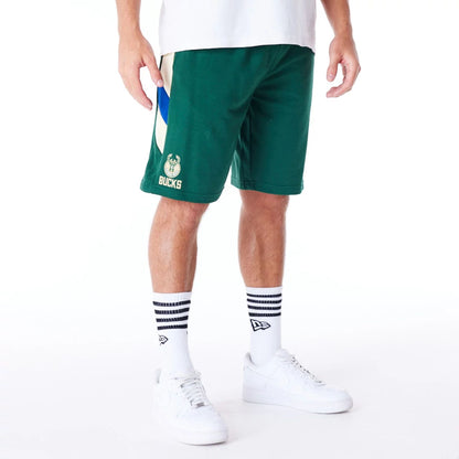 The Male model is wearing Milwaukee Bucks NBA Panel Dark Green Oversized Shorts 1