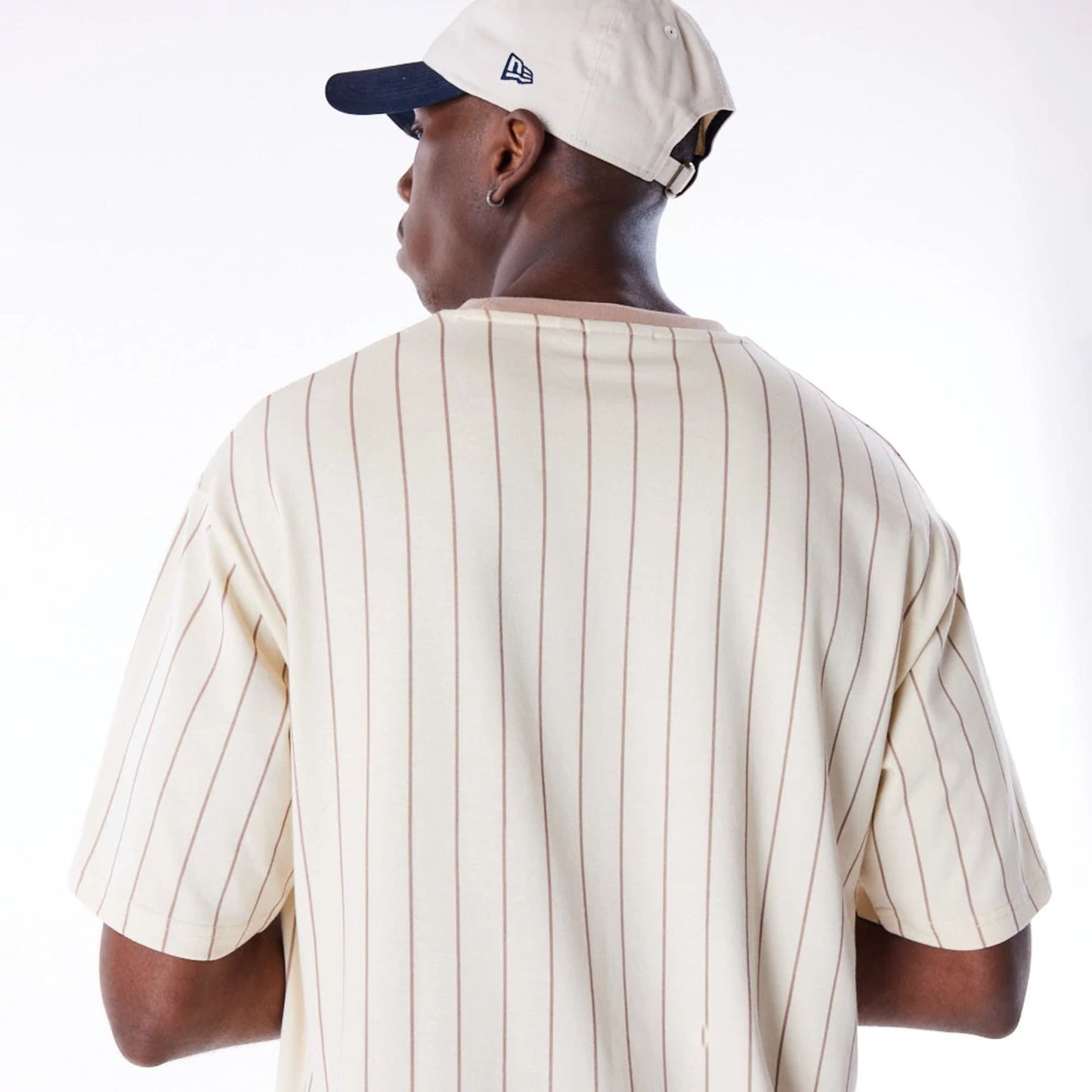 The Male model is wearing New Era Pinstripe Stone Oversized T-Shirt 4