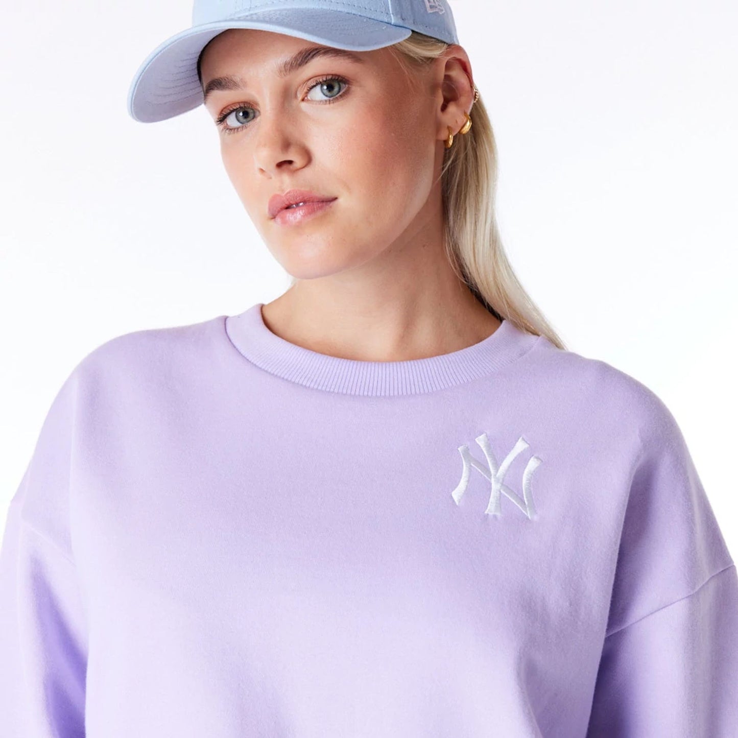 The Female model is wearing New York Yankees Womens MLB League Essential Pastel Purple Crop Crew Neck Sweatshirt 6