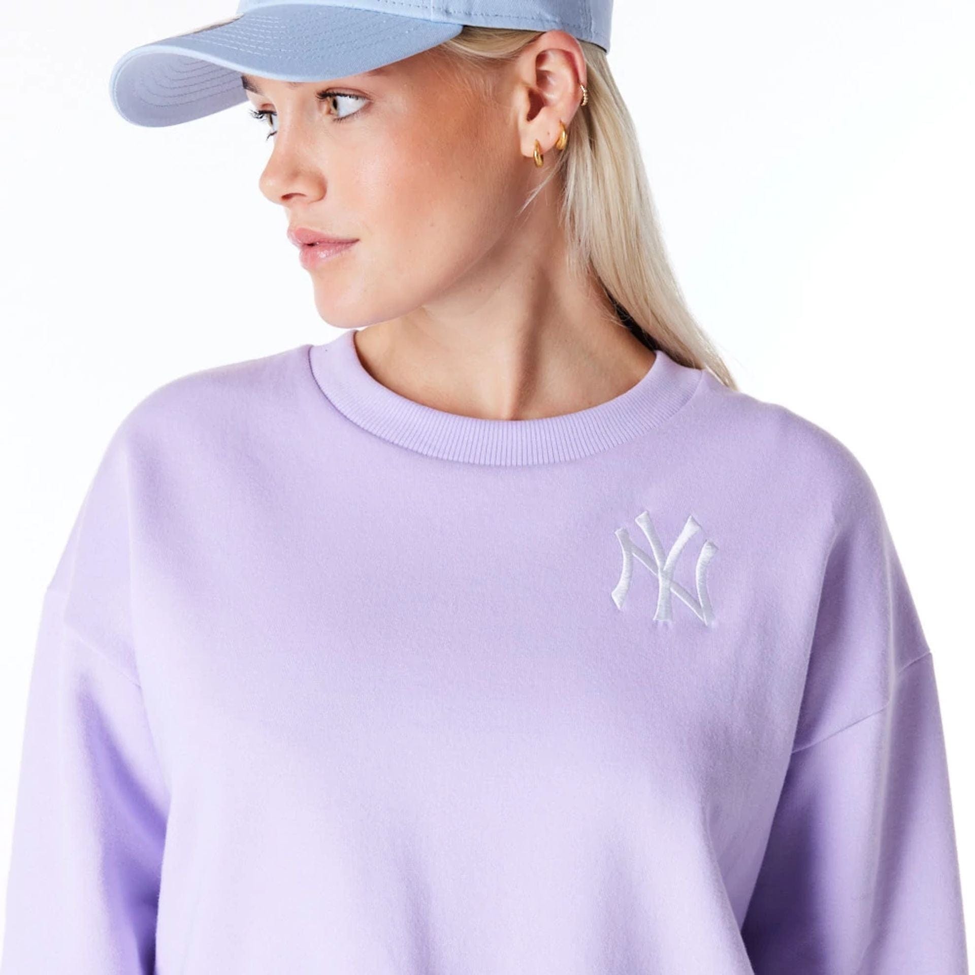 The Female model is wearing New York Yankees Womens MLB League Essential Pastel Purple Crop Crew Neck Sweatshirt 7