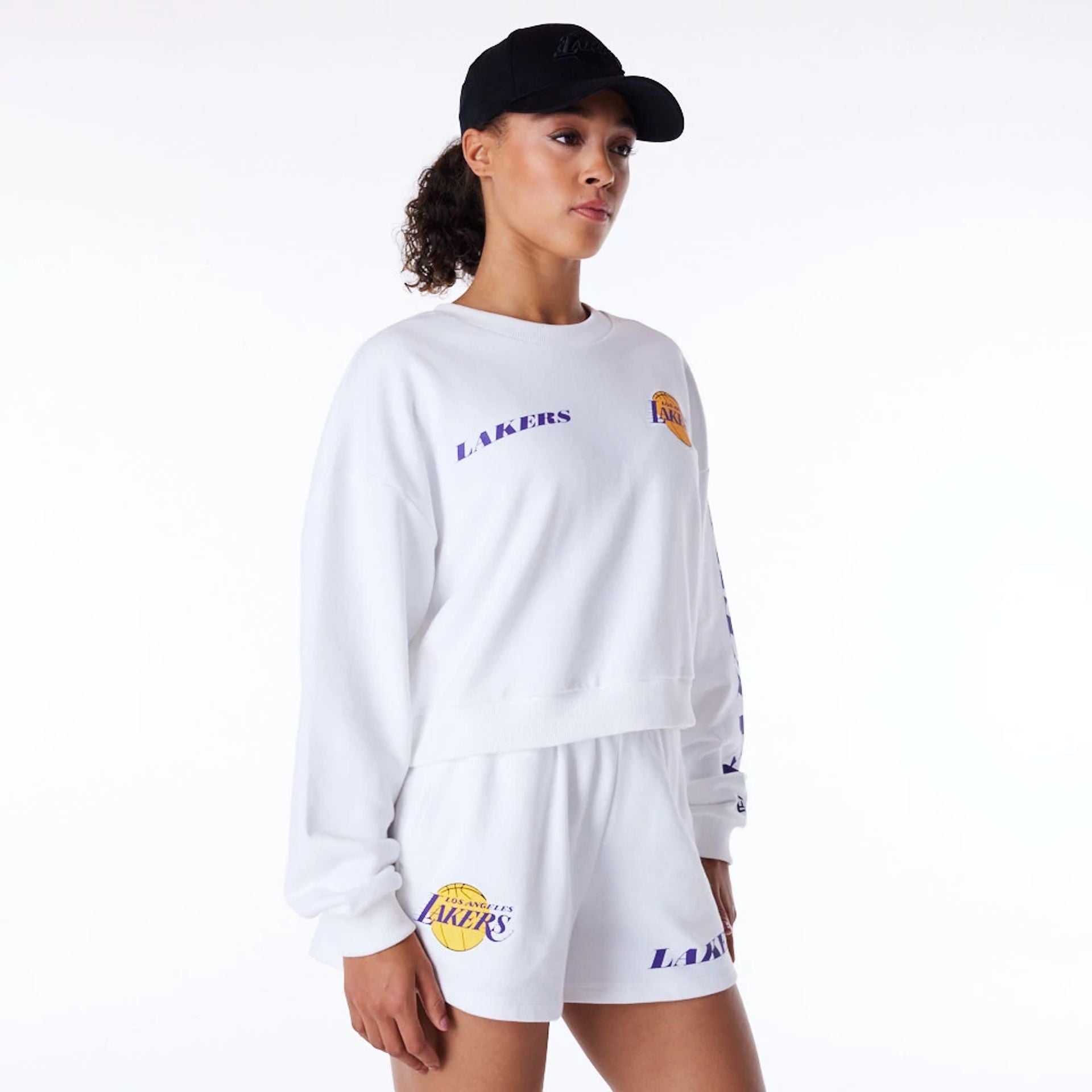 The Female model is wearing LA Lakers Womens NBA Wordmark White Crop Crew Neck Sweatshirt 5