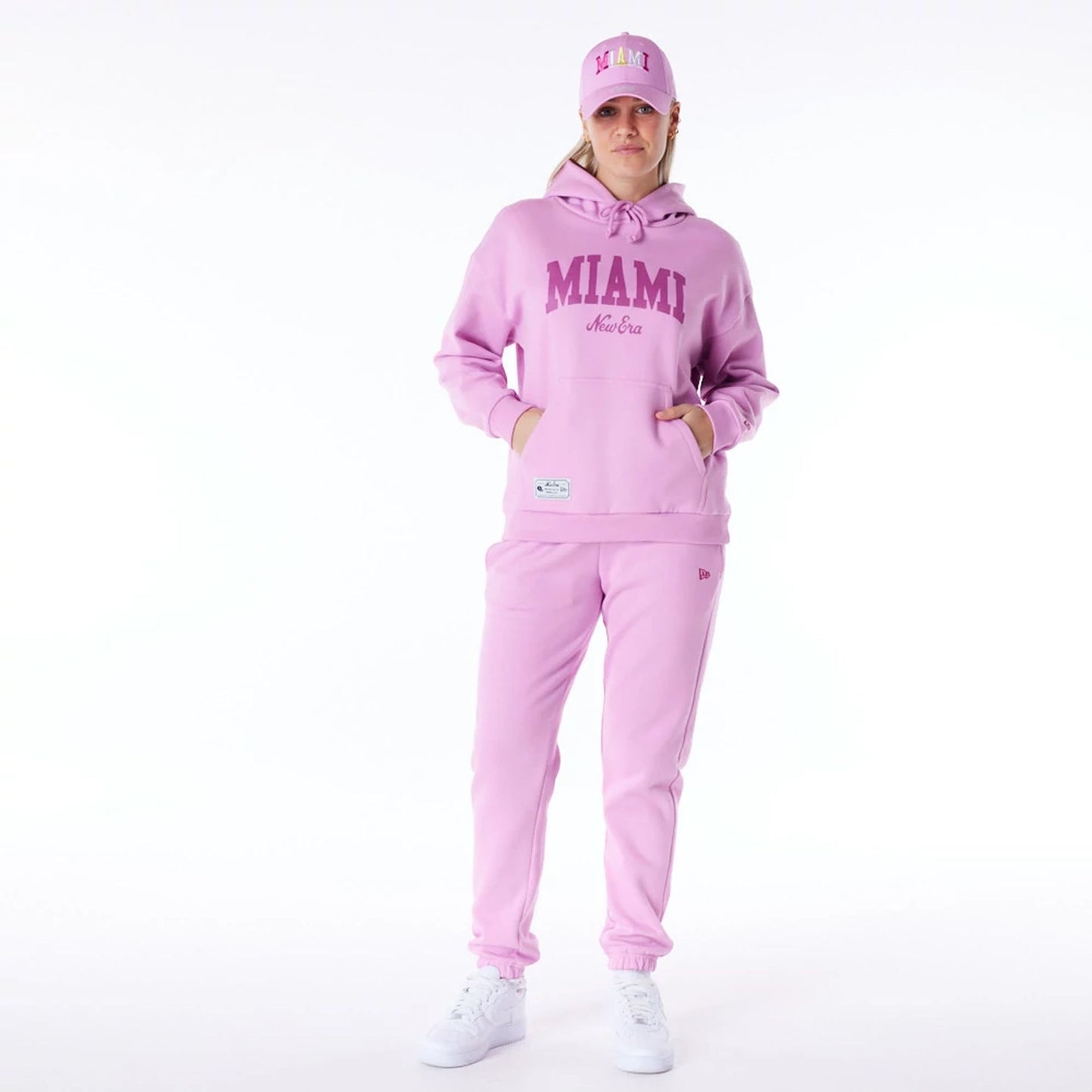 The Female model is wearing New Era Infill Pastel Pink Oversized Pullover Hoodie 2