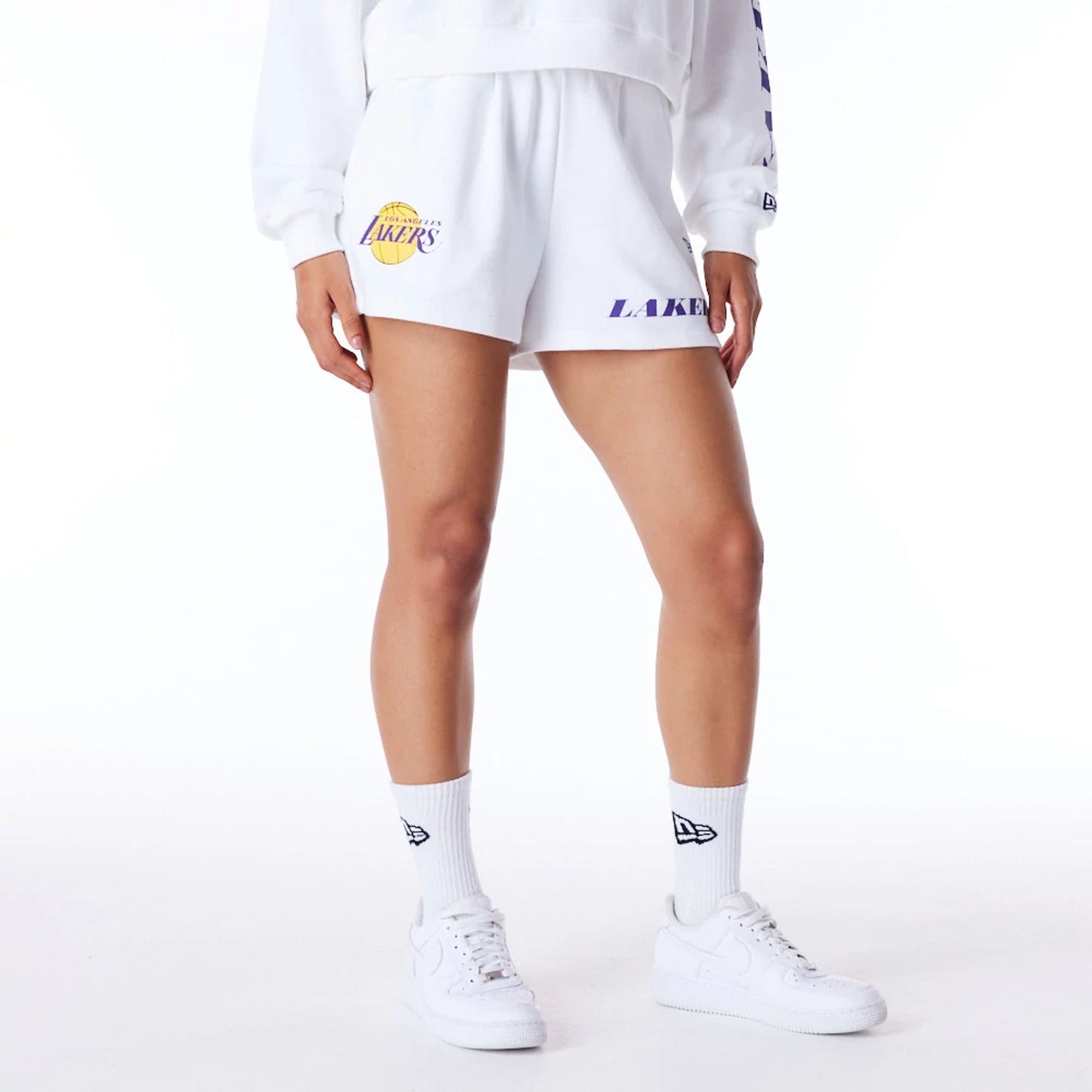 The Female model is wearing LA Lakers Womens NBA Wordmark White Shorts 1