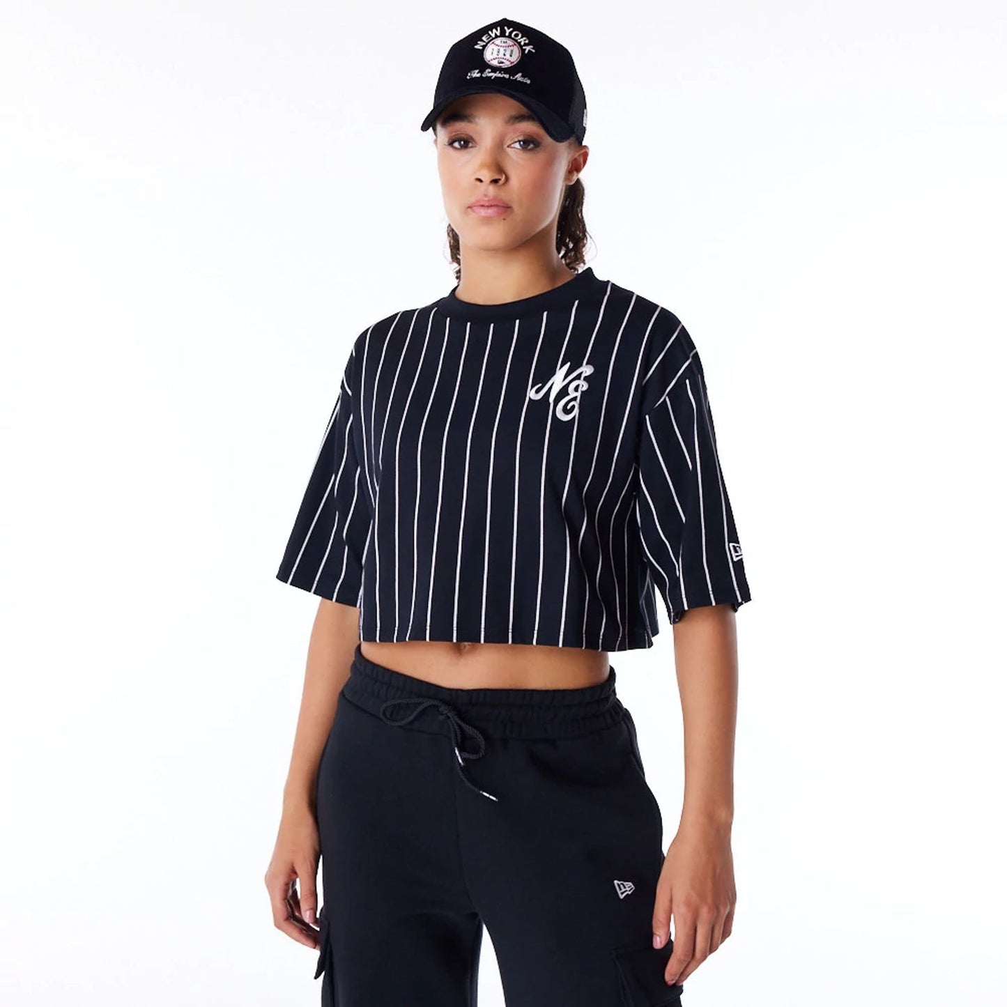 The Female model is wearing New Era Womens Pinstripe Black Crop T-Shirt 1