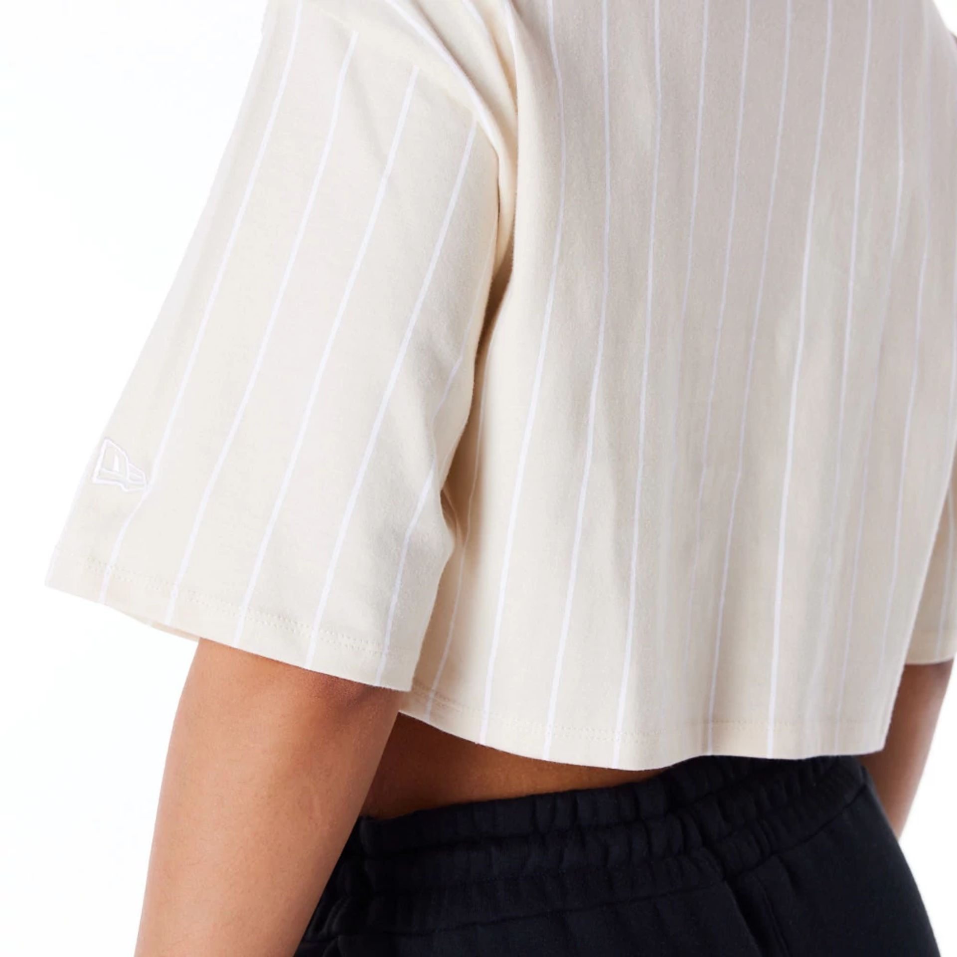 The Female model is wearing New Era Womens Pinstripe Light Beige Crop T-Shirt 3