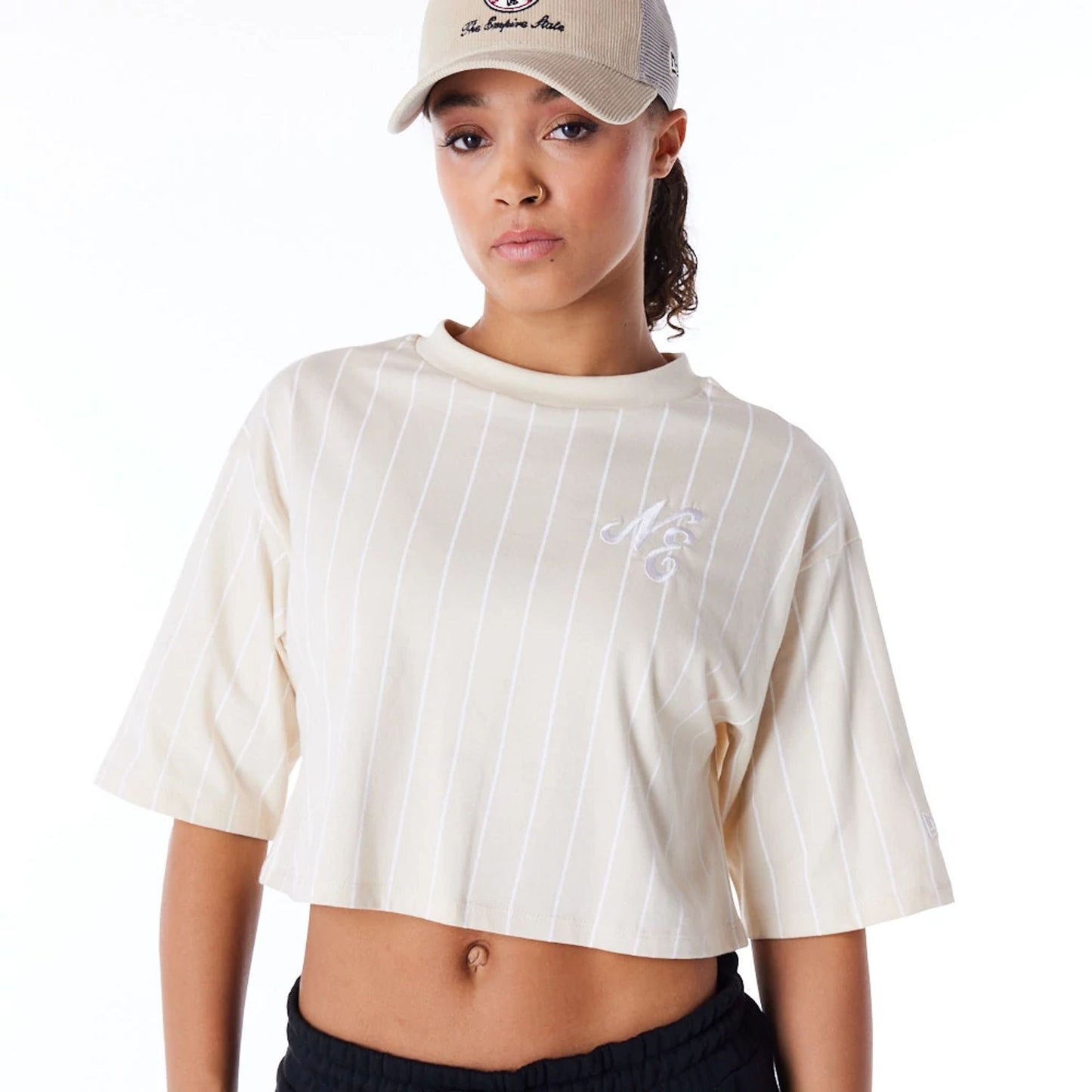 The Female model is wearing New Era Womens Pinstripe Light Beige Crop T-Shirt 5