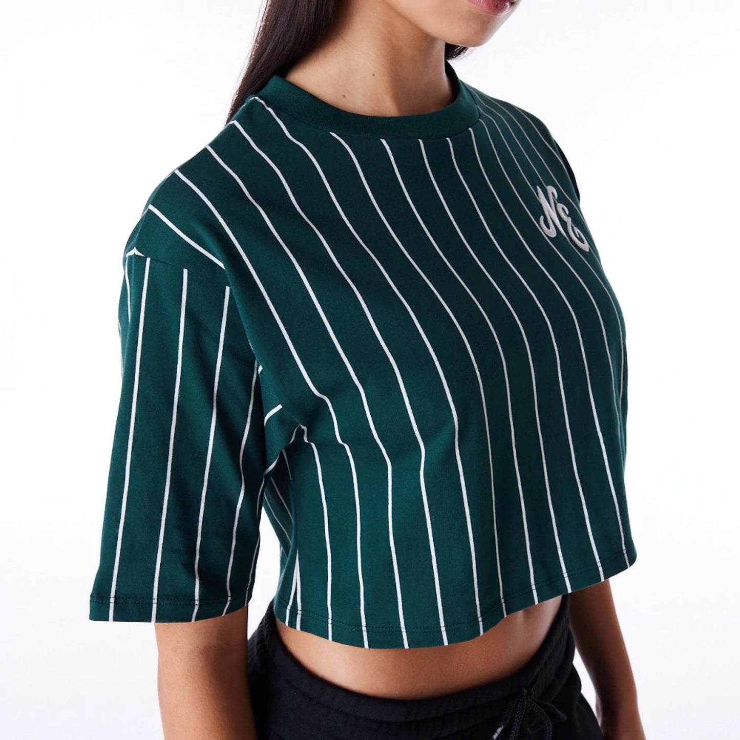 The Female model is wearing New Era Womens Pinstripe Dark Green Crop T-Shirt 4